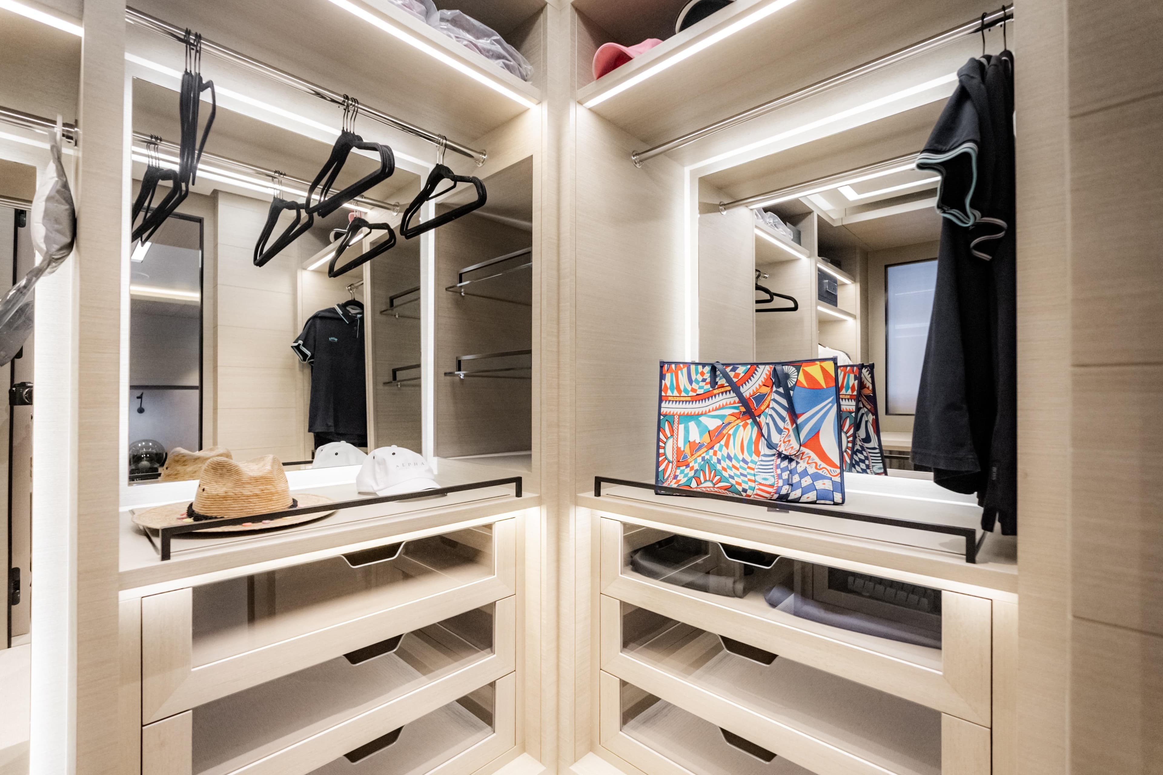 Luxurious walk-in closet with modern lighting, stylish storage, and colorful bag on display.