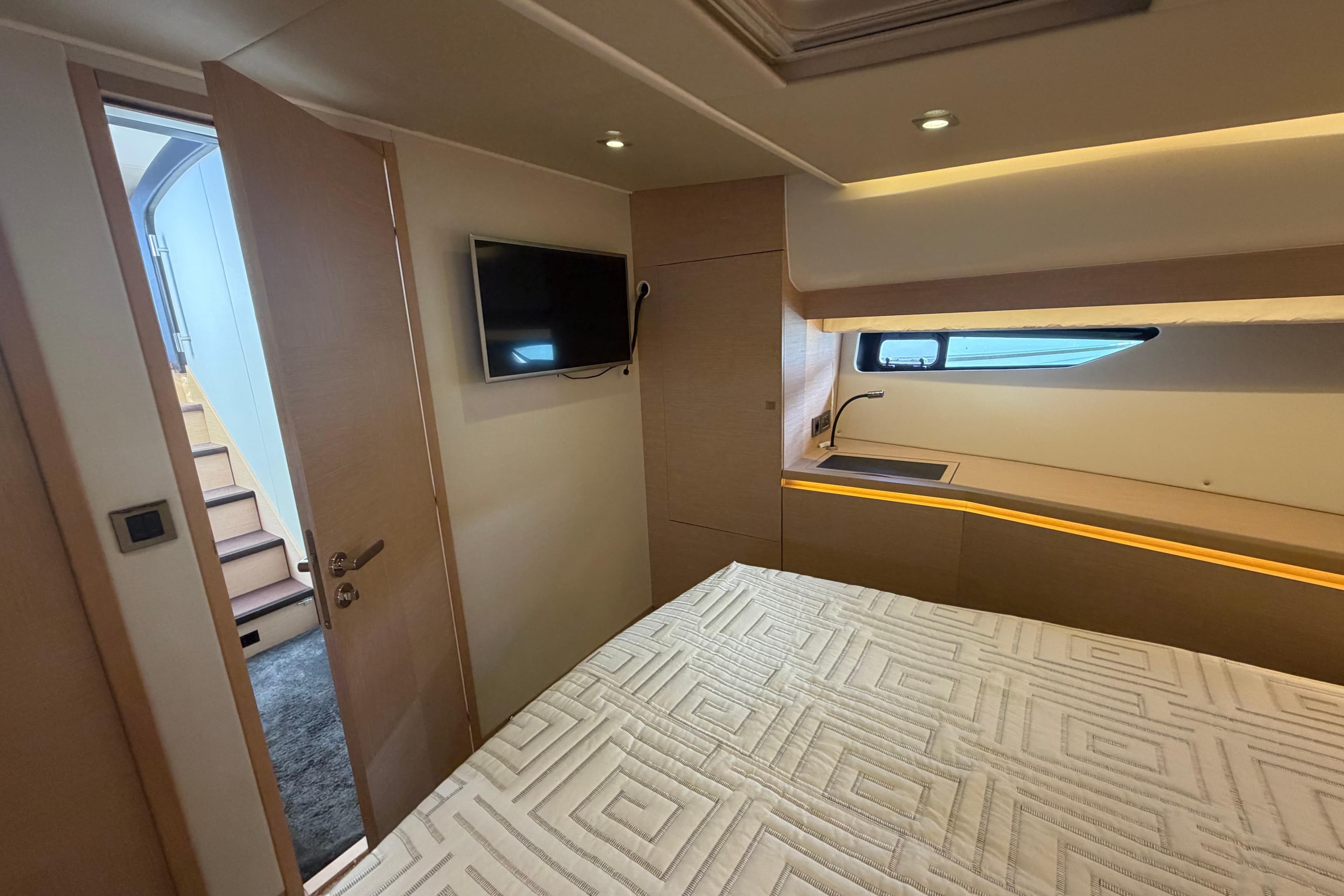 Luxurious 2015 Prestige 550 yacht bedroom with modern decor and window view.