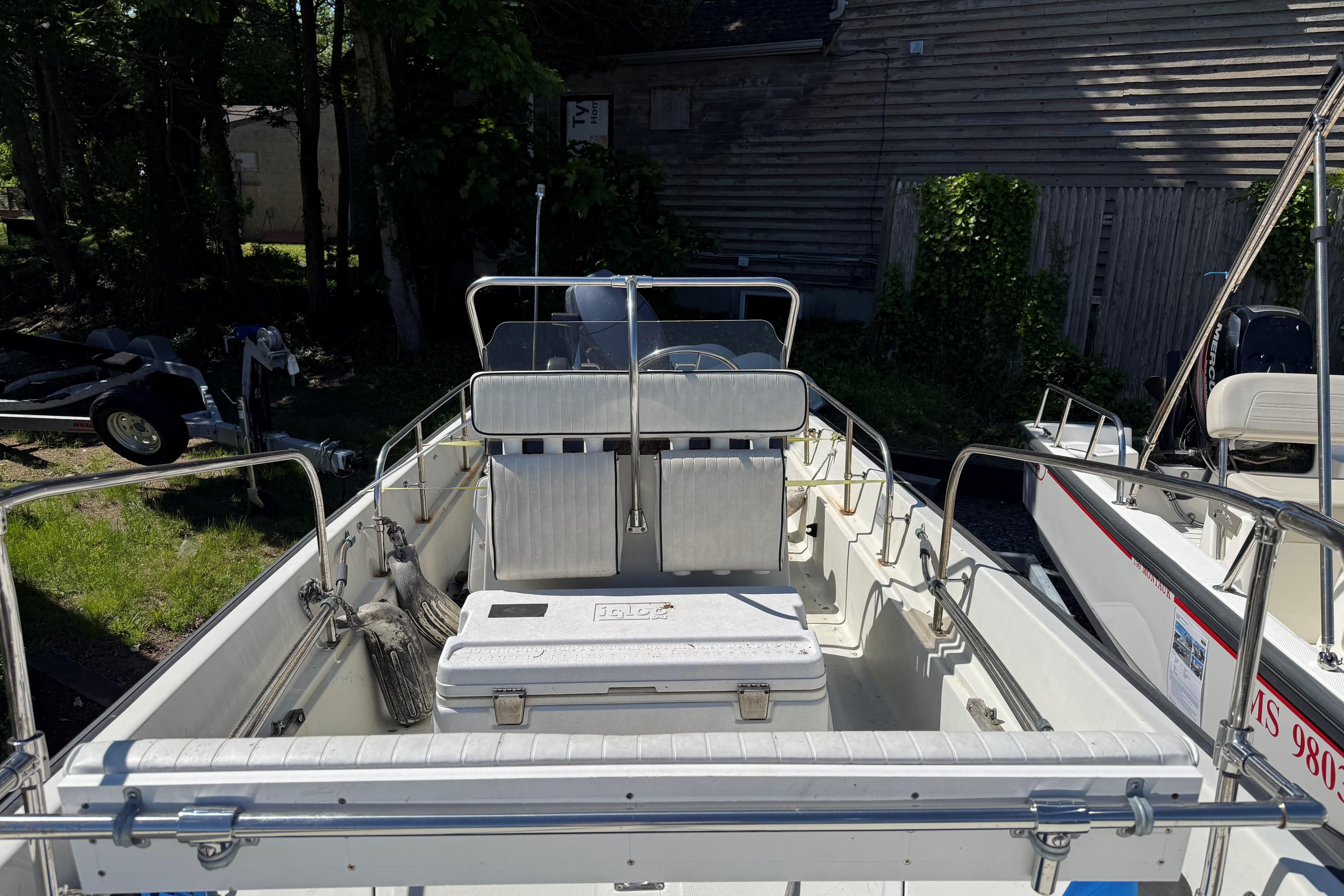1994 Boston Whaler 17 Montauk boat interior with seating and cooler, parked outdoors.