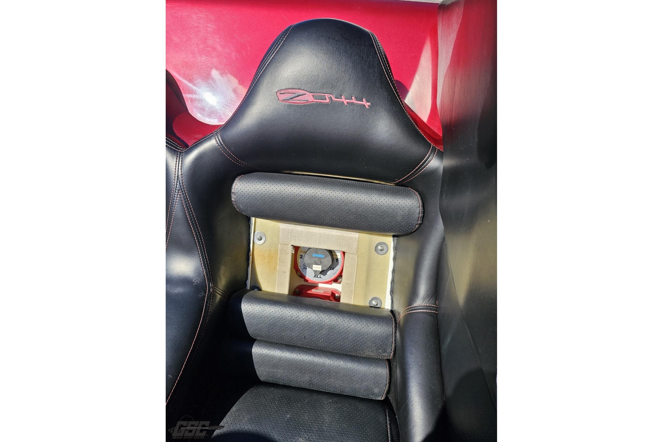 Black leather car seat with red stitching in a 2010 MTI 44 Corvette.