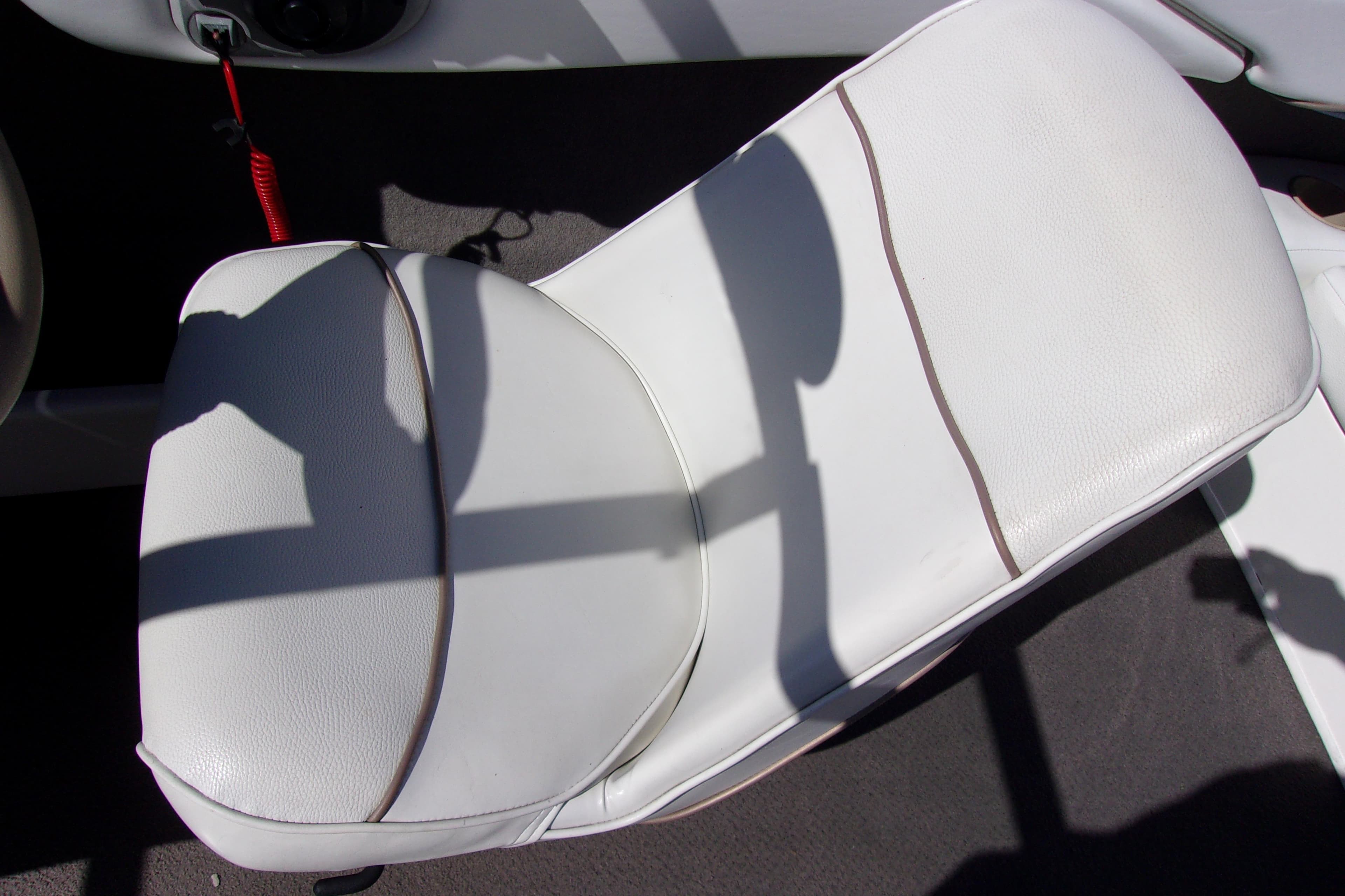 White seat on a 2003 Bayliner 205 boat, featuring clean upholstery and shadow details.