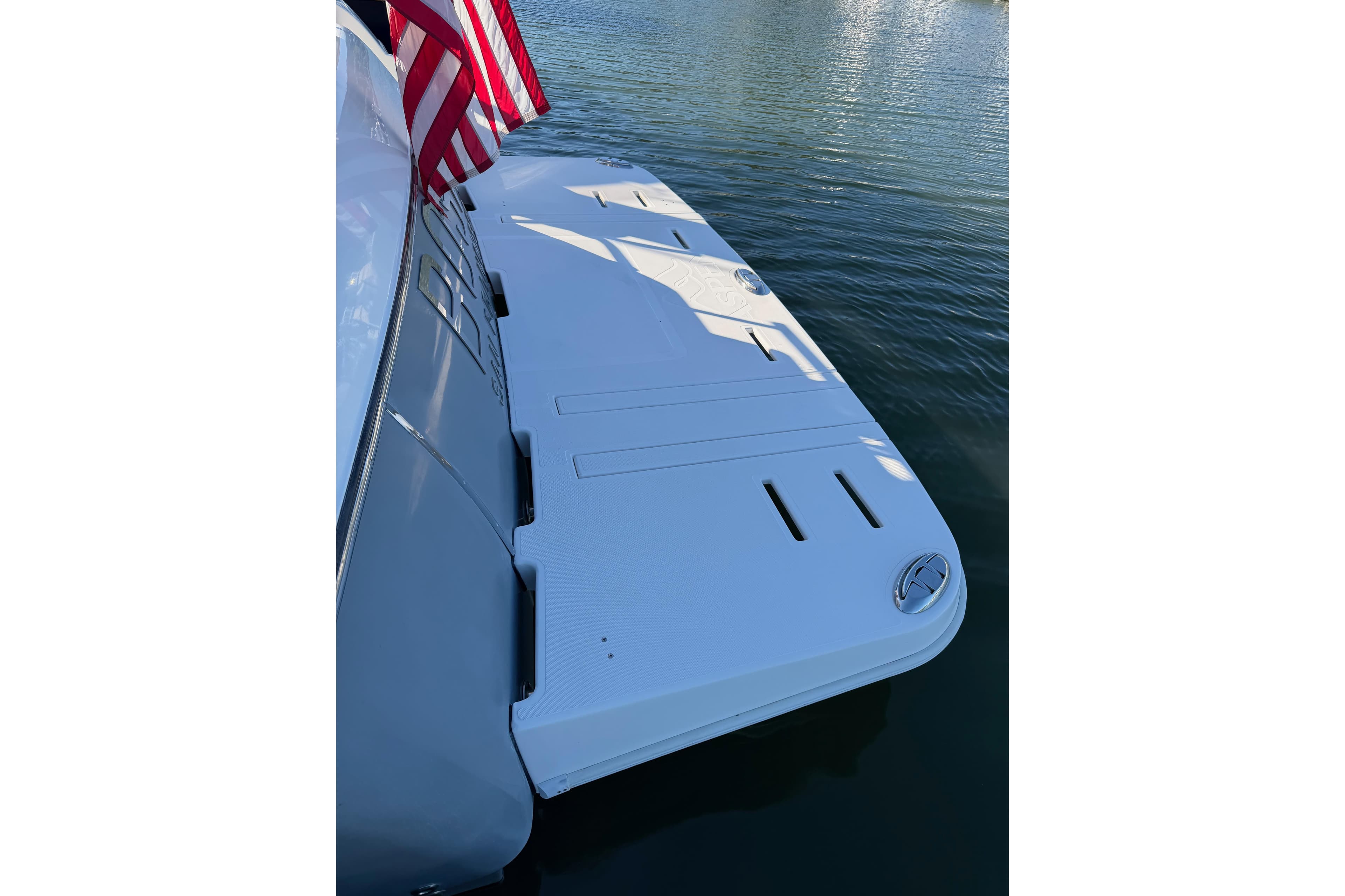 Rear view of a 2017 Aspen C120 boat with swim platform and American flag.