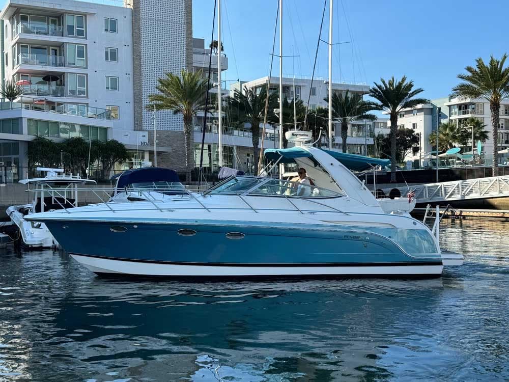 2005 Formula 31 Performance Cruiser docked in a marina with palm trees and buildings.