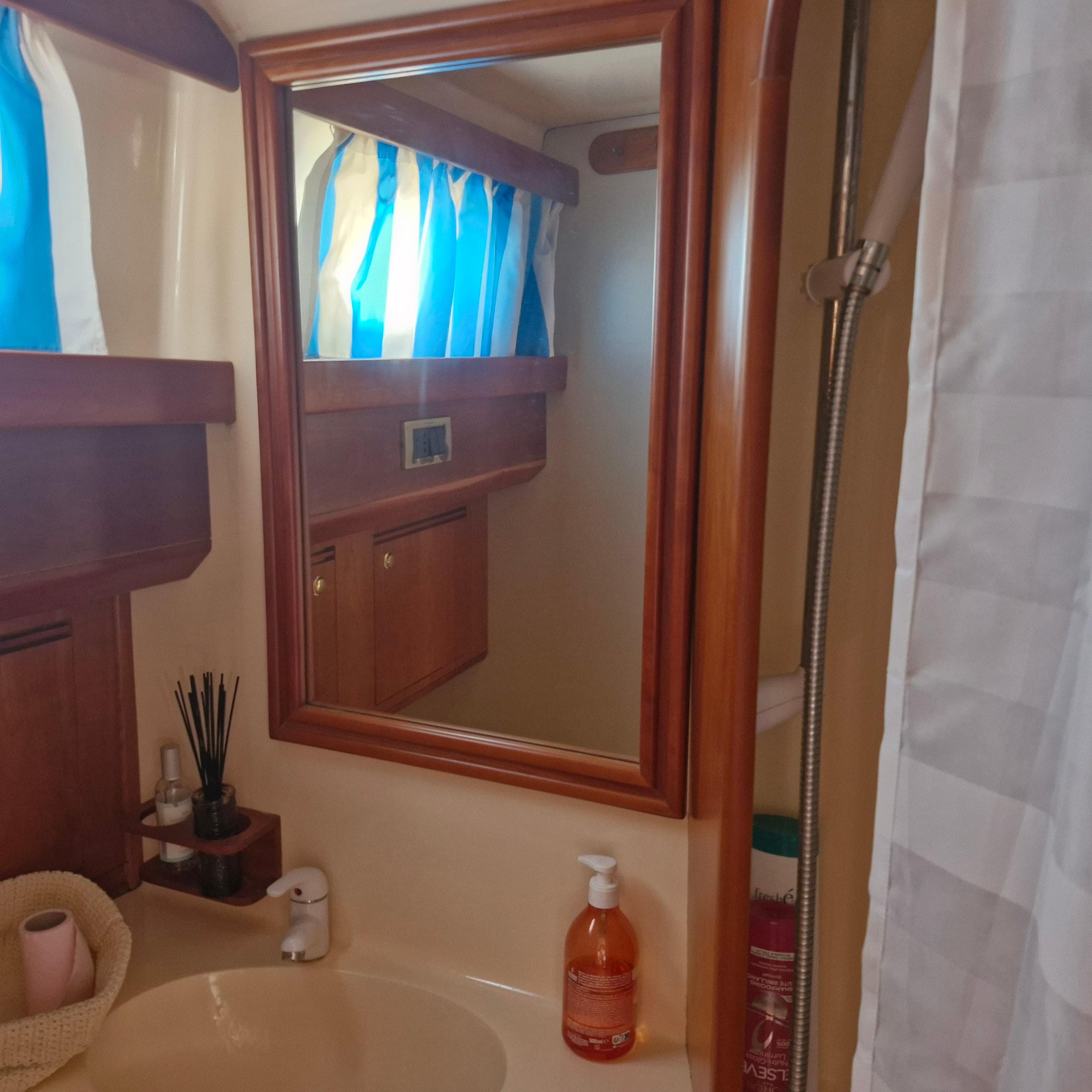 Bathroom interior of 2001 Apreamare 10 Cabinato yacht with mirror and sink.