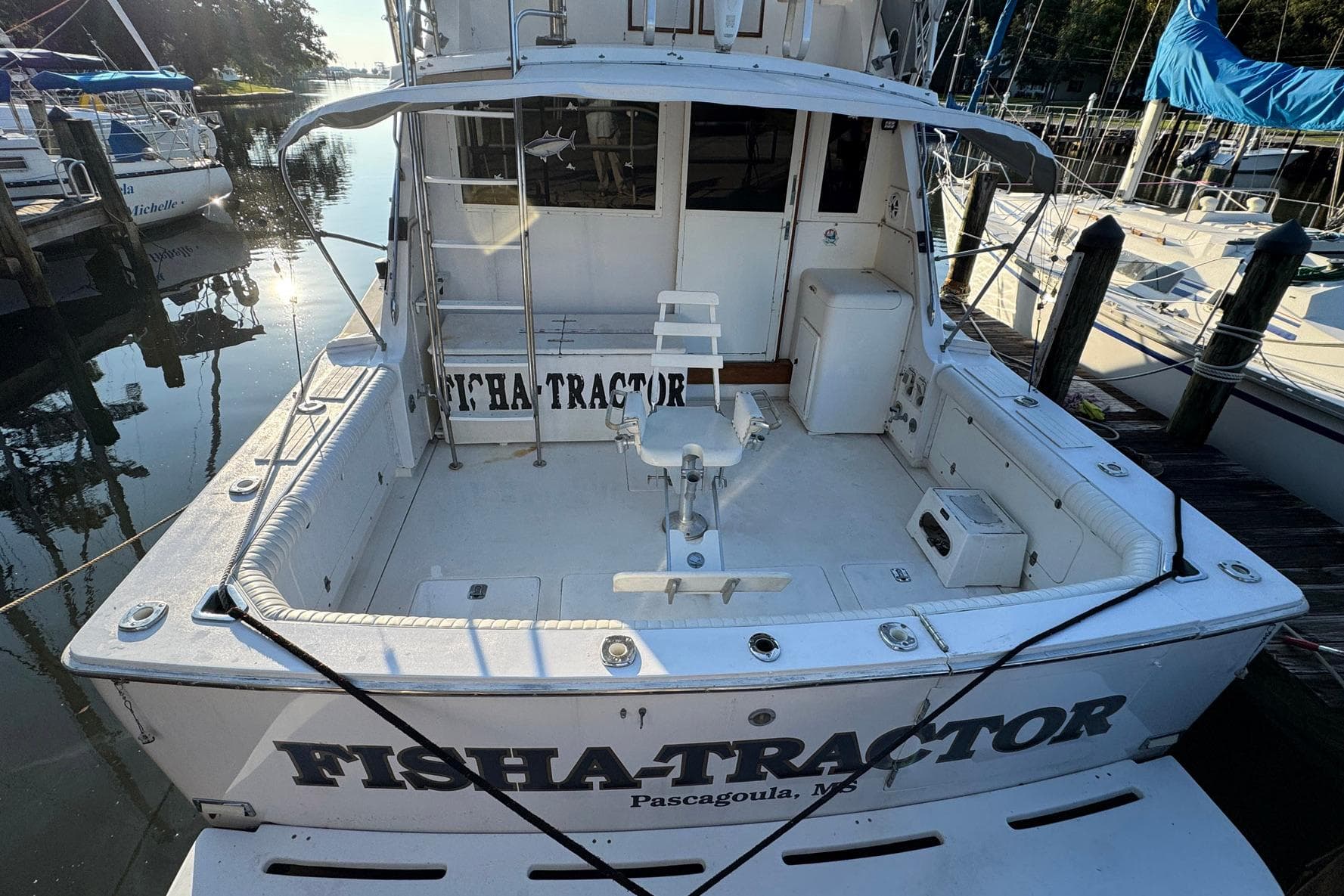 1979 Bertram 38 Convertible boat docked, featuring spacious fishing deck and seating.