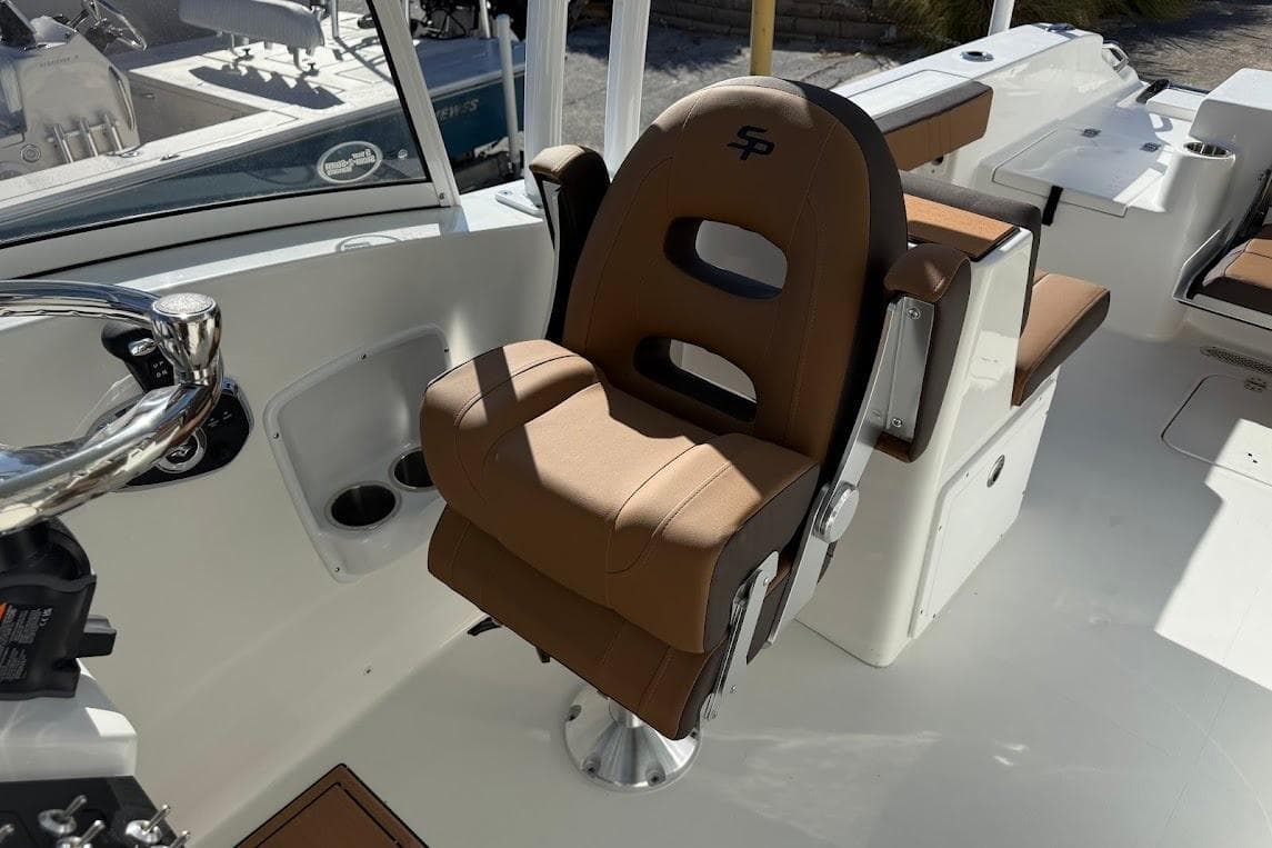 2026 Sea Pro 240 Dual Console boat interior with brown captain's chair and steering wheel.