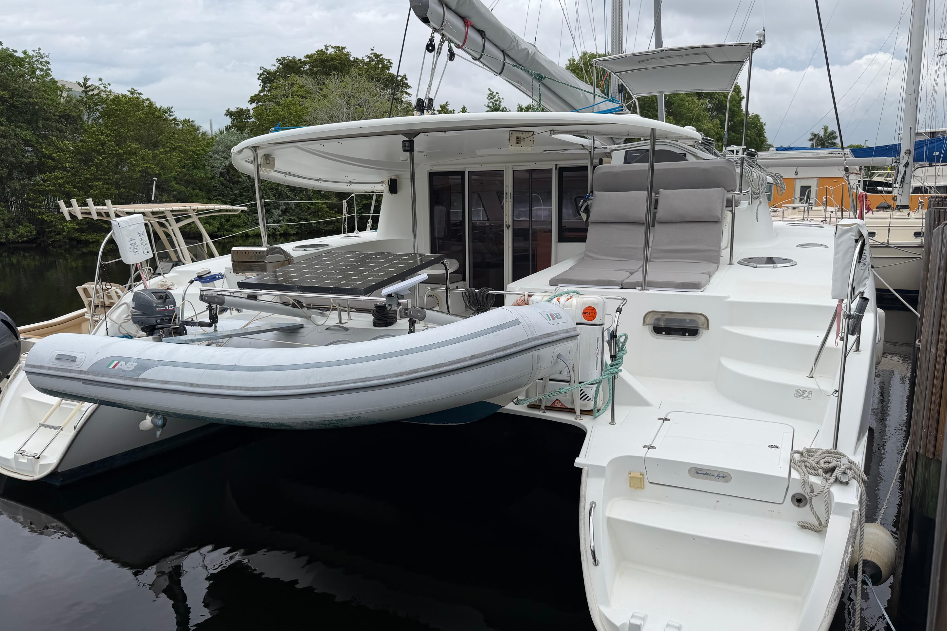 2009 Fountaine Pajot Orana 44 catamaran with dinghy, docked in a serene marina setting.