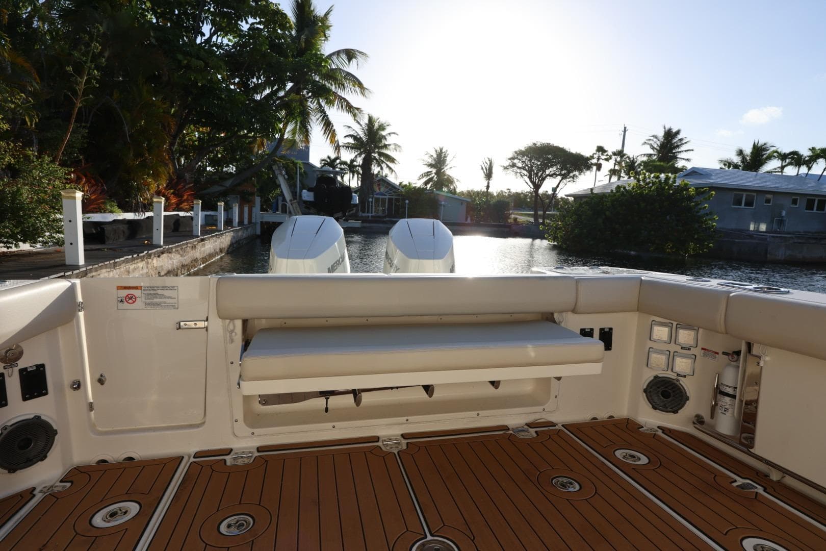 2025 Boston Whaler 325 Conquest boat interior with teak flooring and scenic waterfront view.