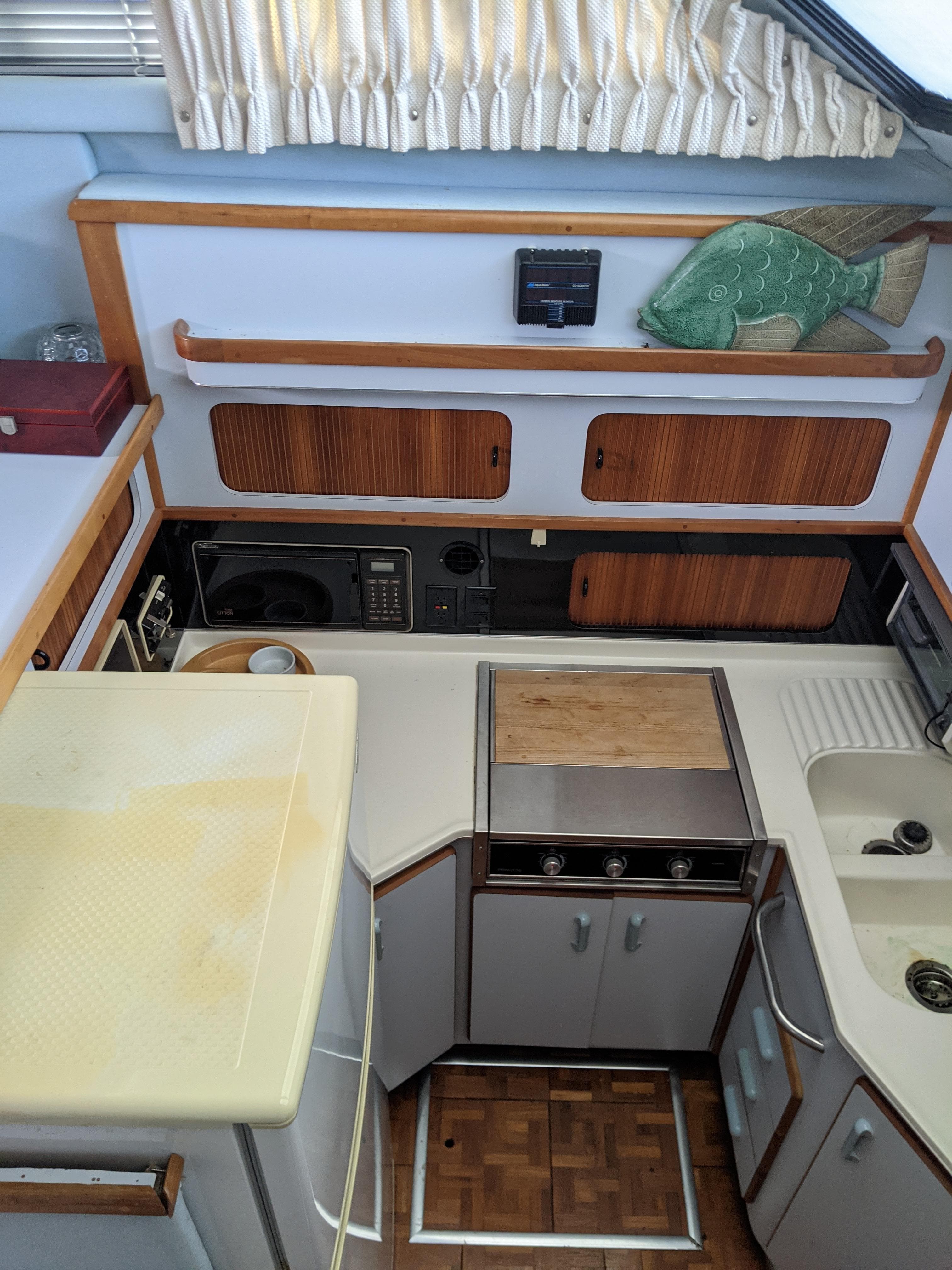 1989 Sea Ray 380 Aft Cabin kitchen with wooden cabinets and appliances.