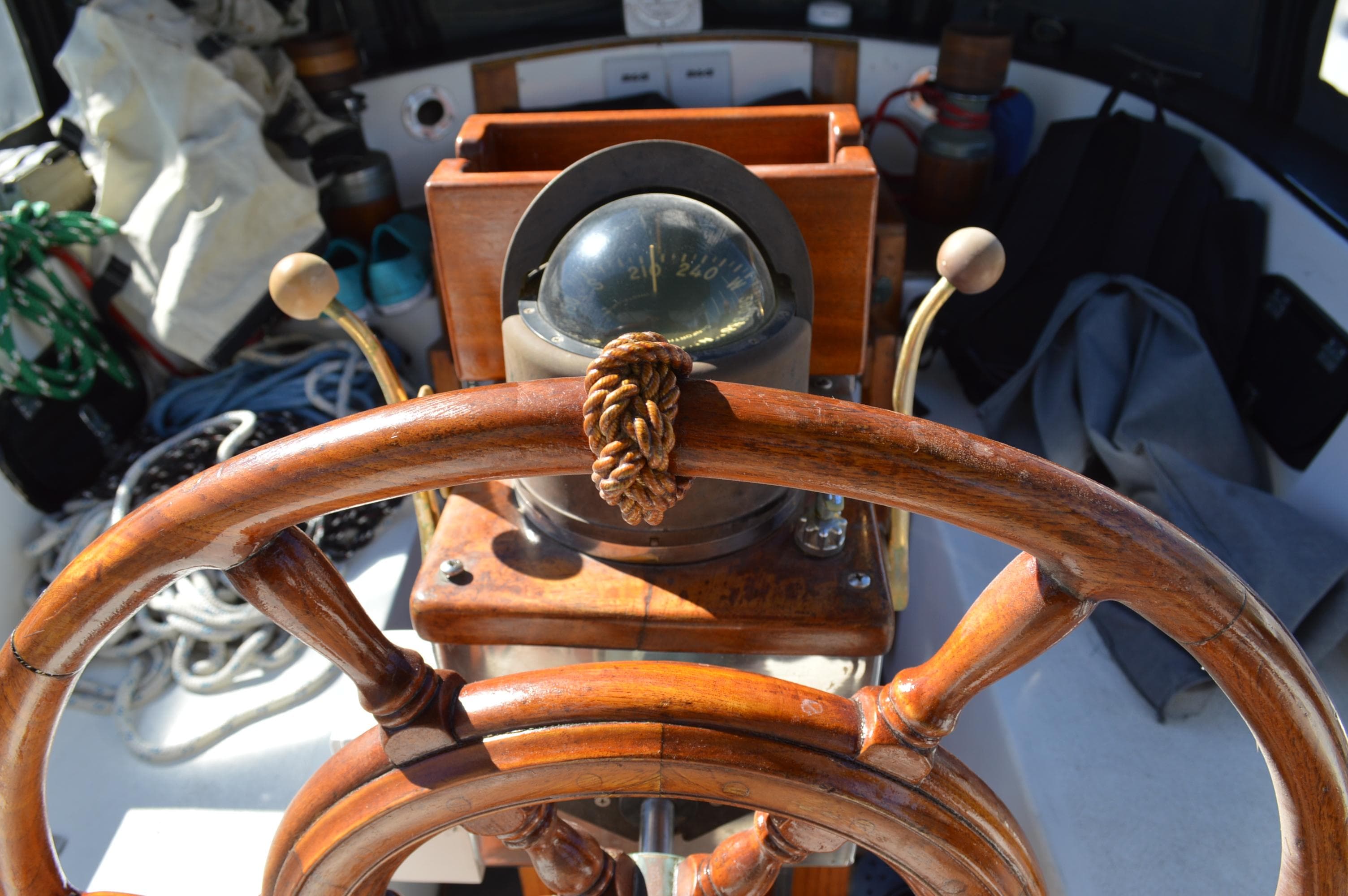 Wooden helm and compass on a 1979 Robert Perry 47 sailboat.