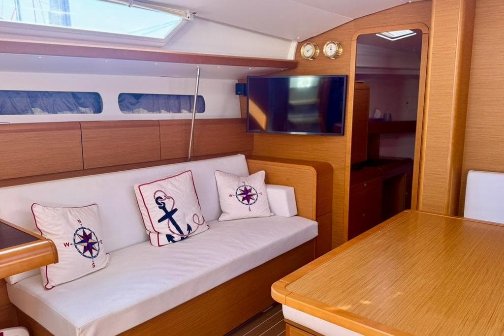 Interior of 2017 Jeanneau Sun Odyssey 449 yacht with cozy seating and nautical decor.