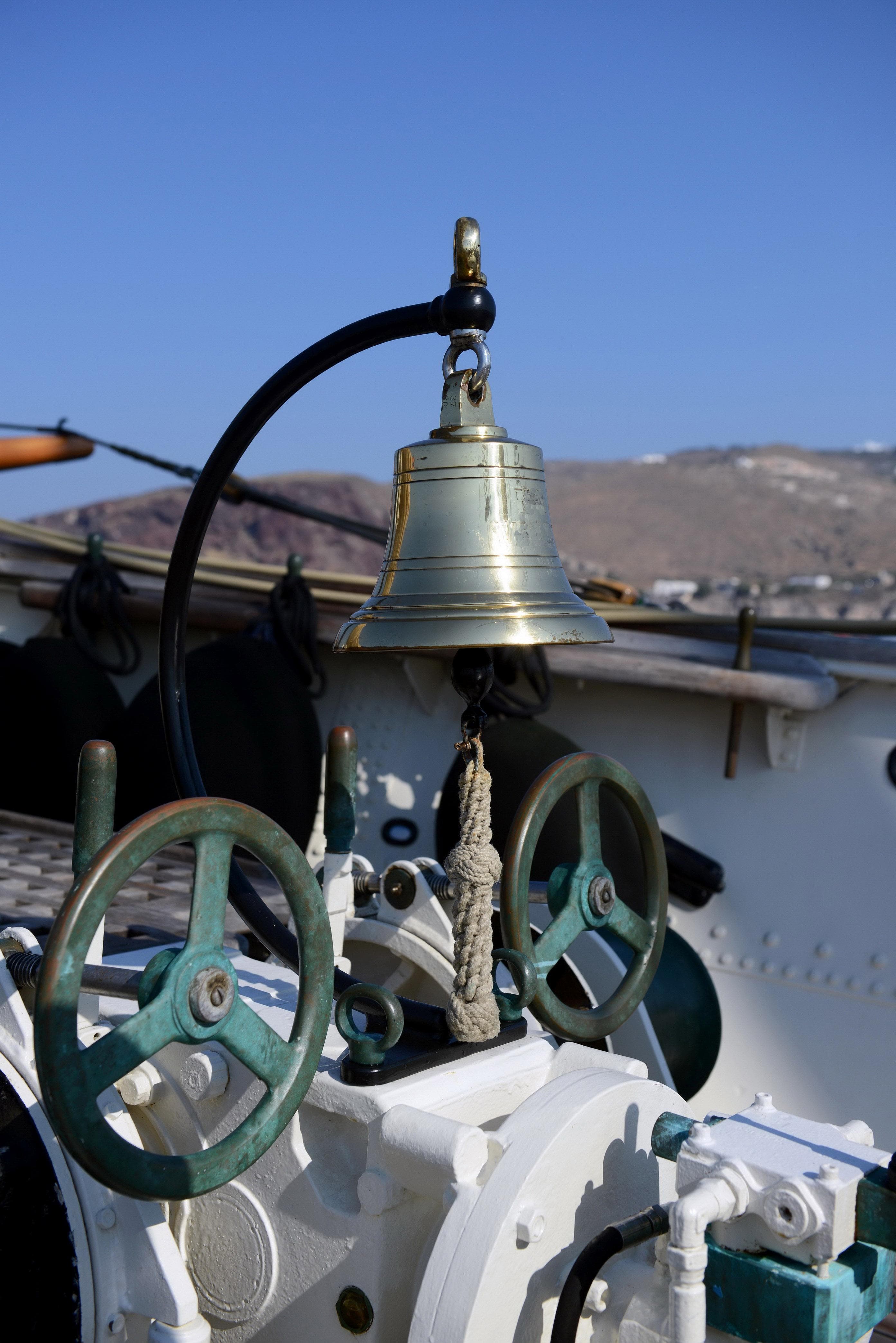 Vintage ship bell on 1920 J.P. Smit Motorsailer Schooner deck, with nautical equipment.