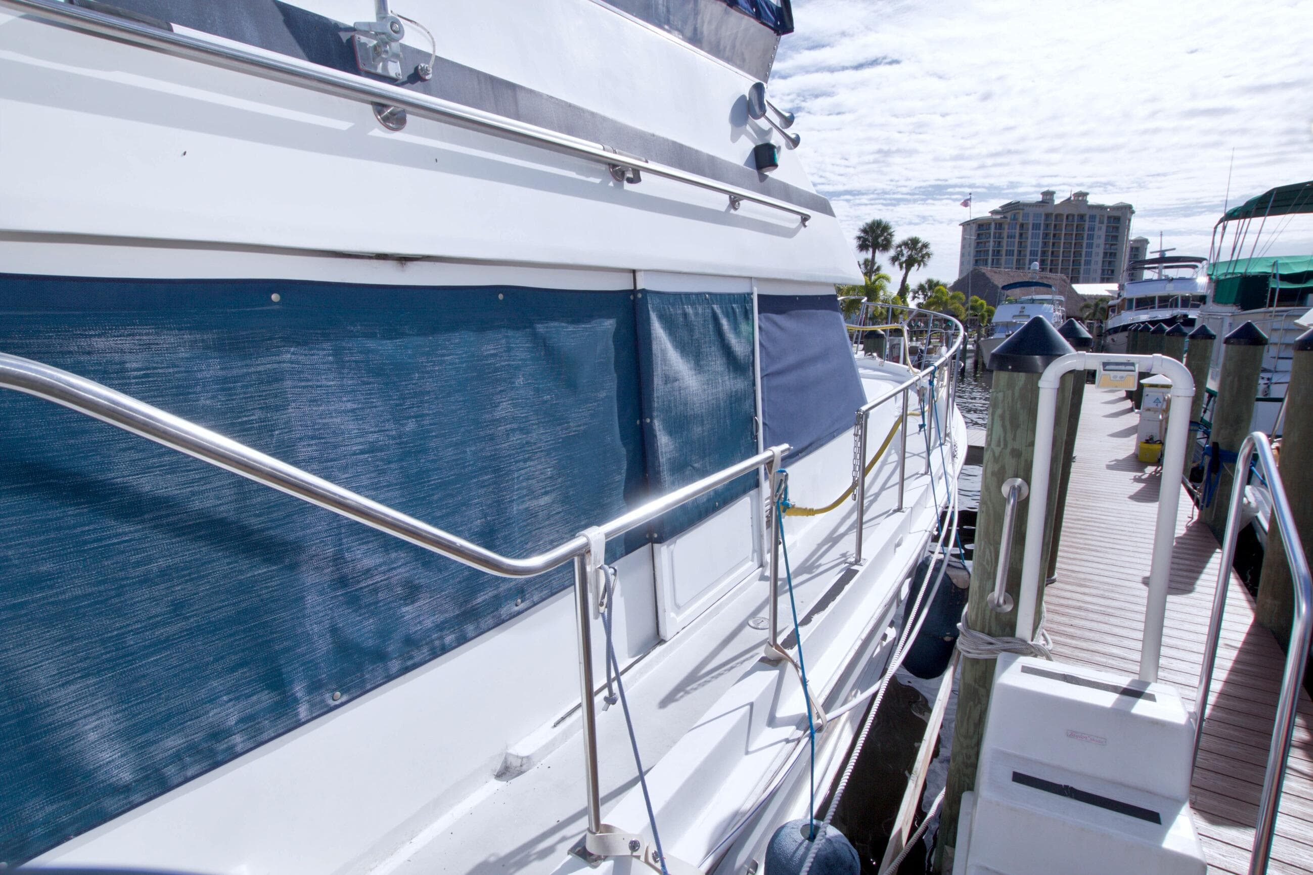 1984 Present Yachts 42 Sundeck docked, featuring blue canvas and stainless steel railings.