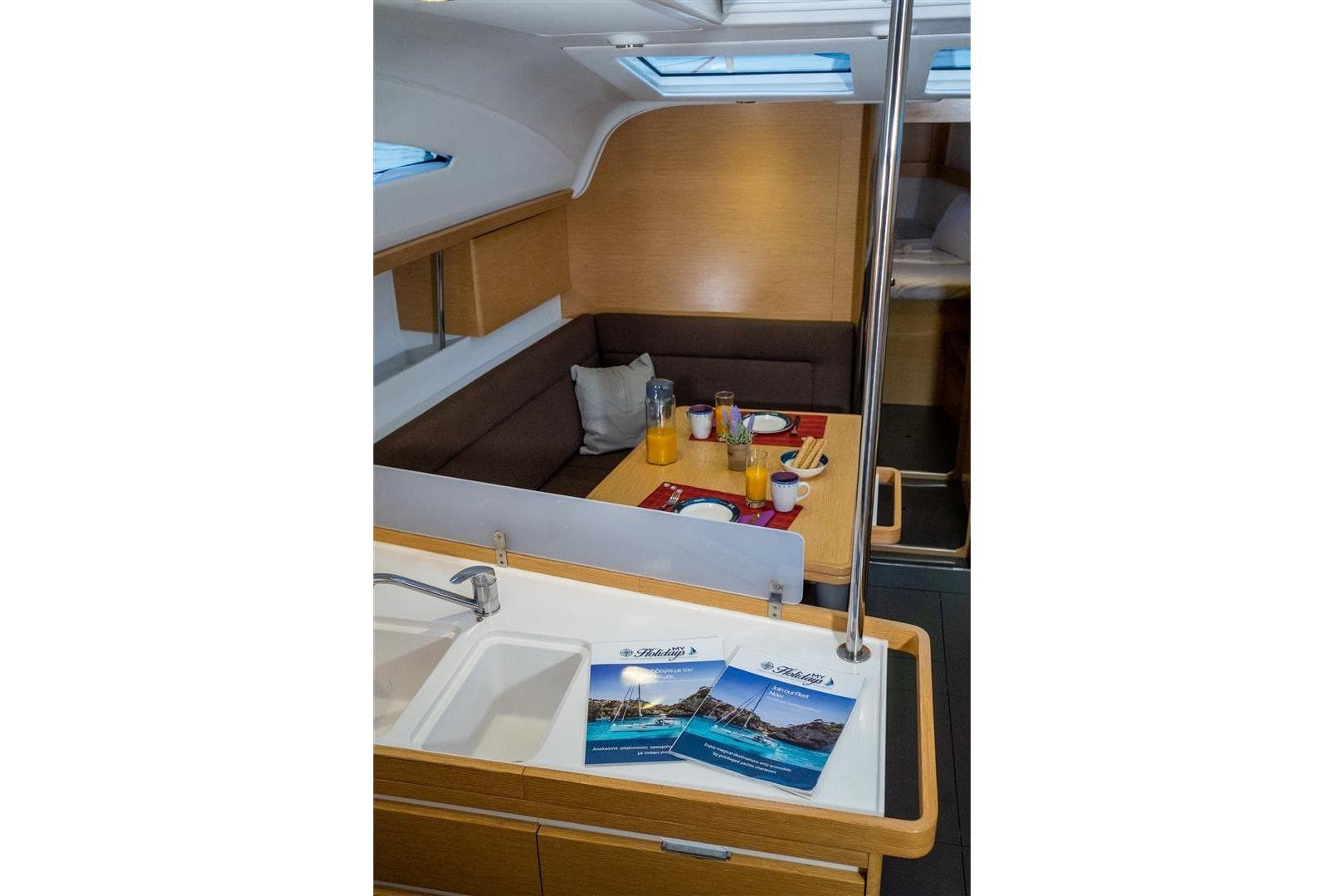 Interior of 2015 Elan Impression 45 yacht with dining area and brochures.
