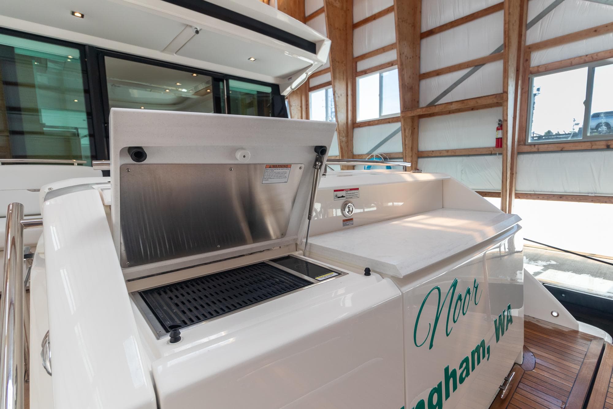 2023 Tiara Yachts C44 Coupe with outdoor grill in a wooden boathouse.