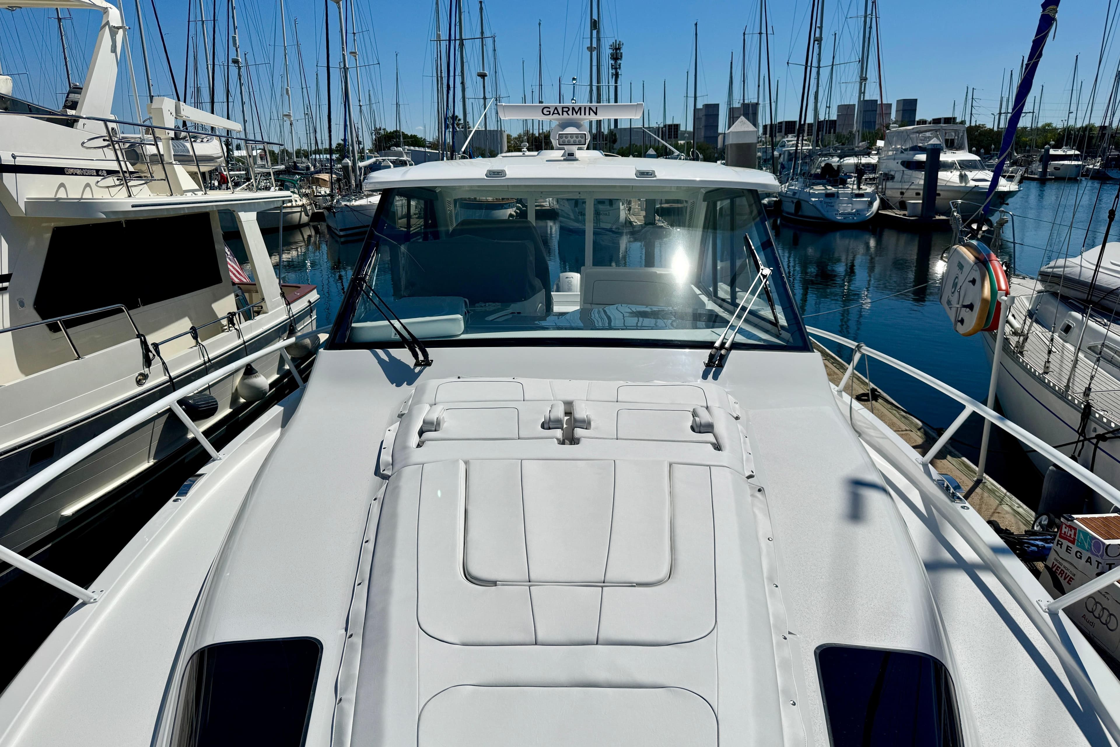2025 Intrepid 50 Evolution yacht docked in a marina, surrounded by sailboats.