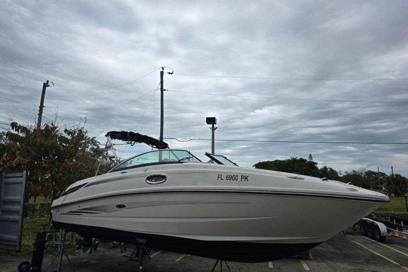 2012 Sea Ray 260 Sundeck boat on trailer under cloudy sky.