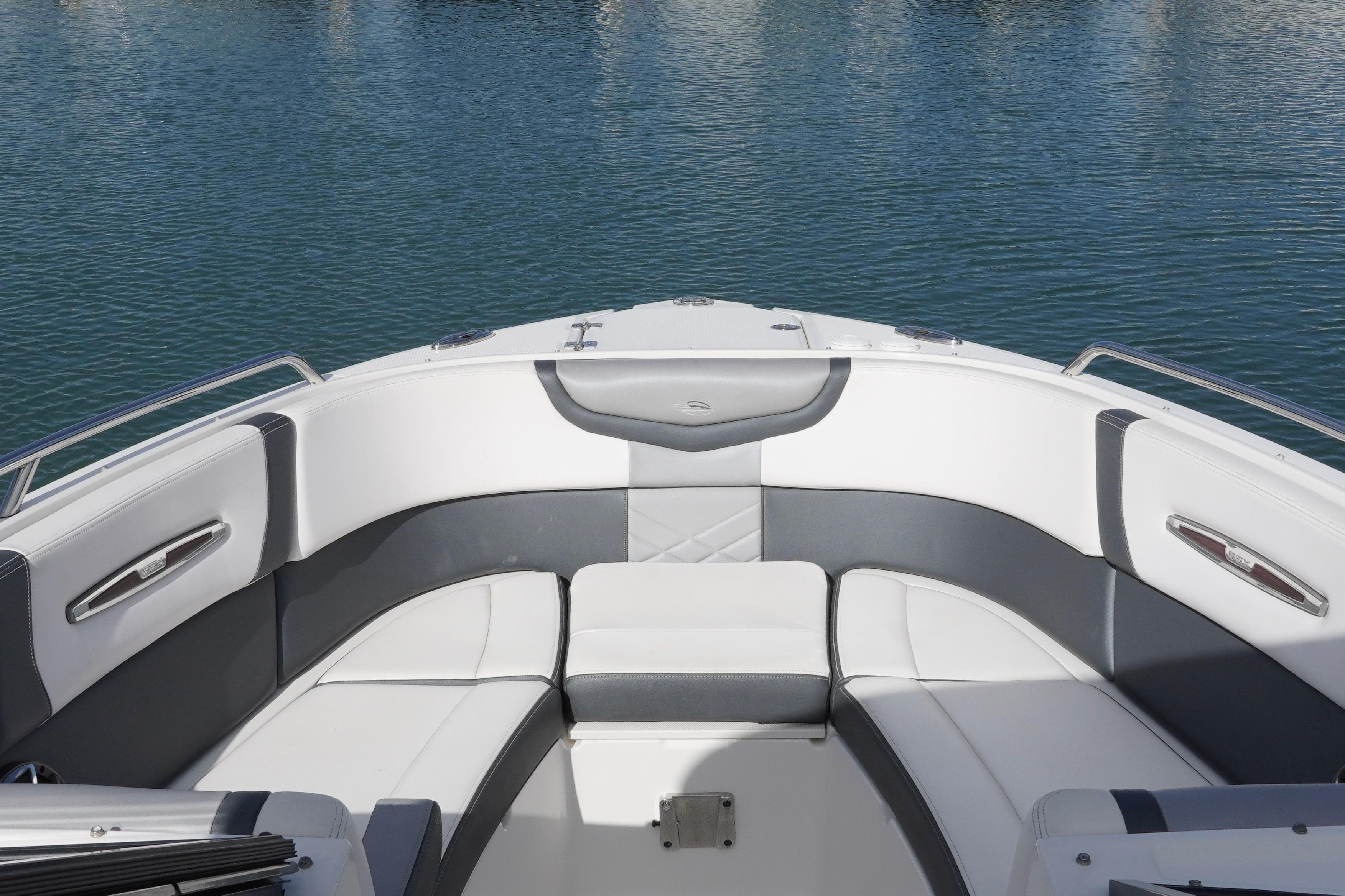2019 Chaparral 227 SSX boat interior with white and gray seating, docked on calm water.