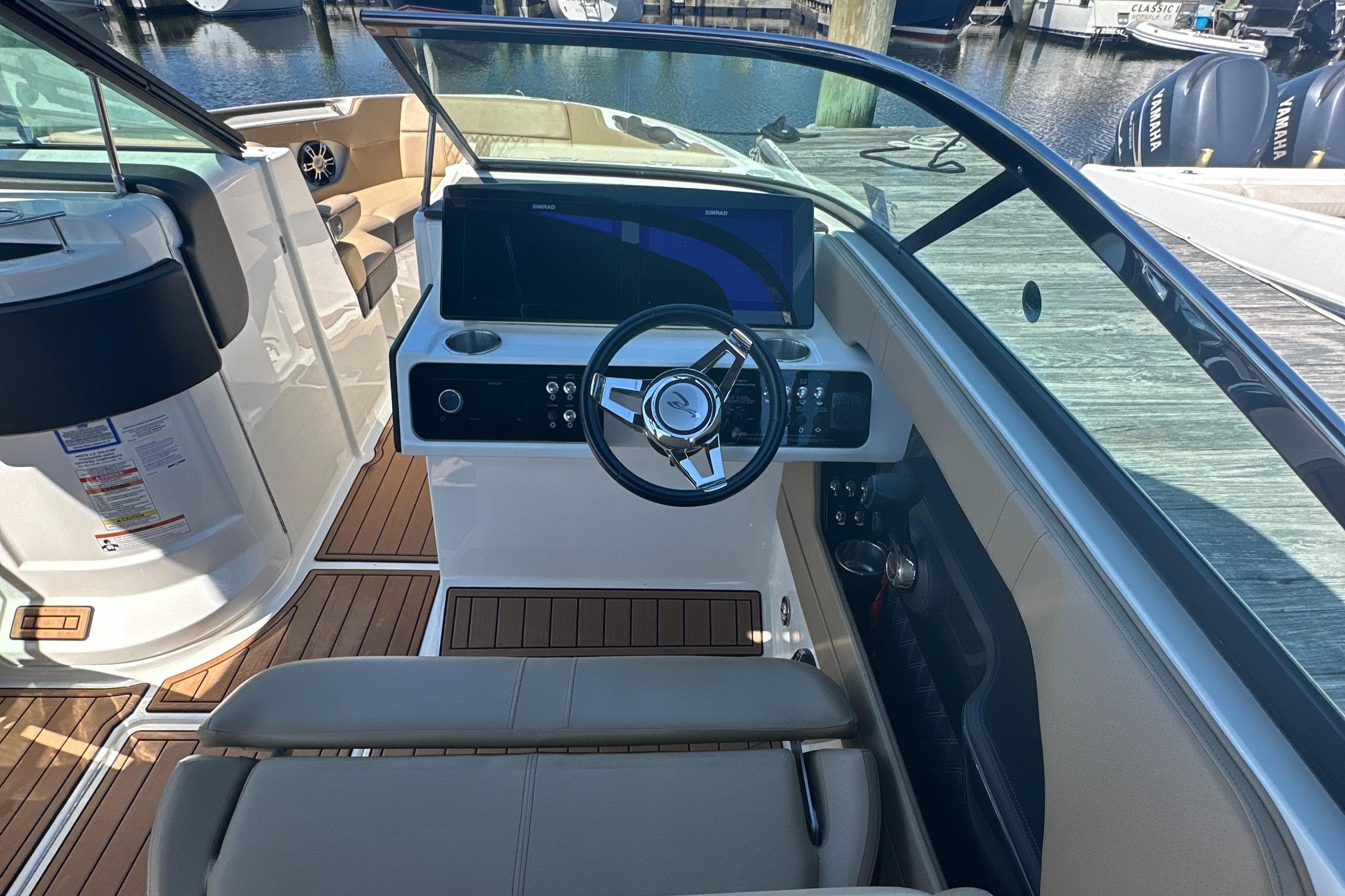 2019 Sea Ray SLX 280 boat cockpit with steering wheel and dashboard, docked at marina.