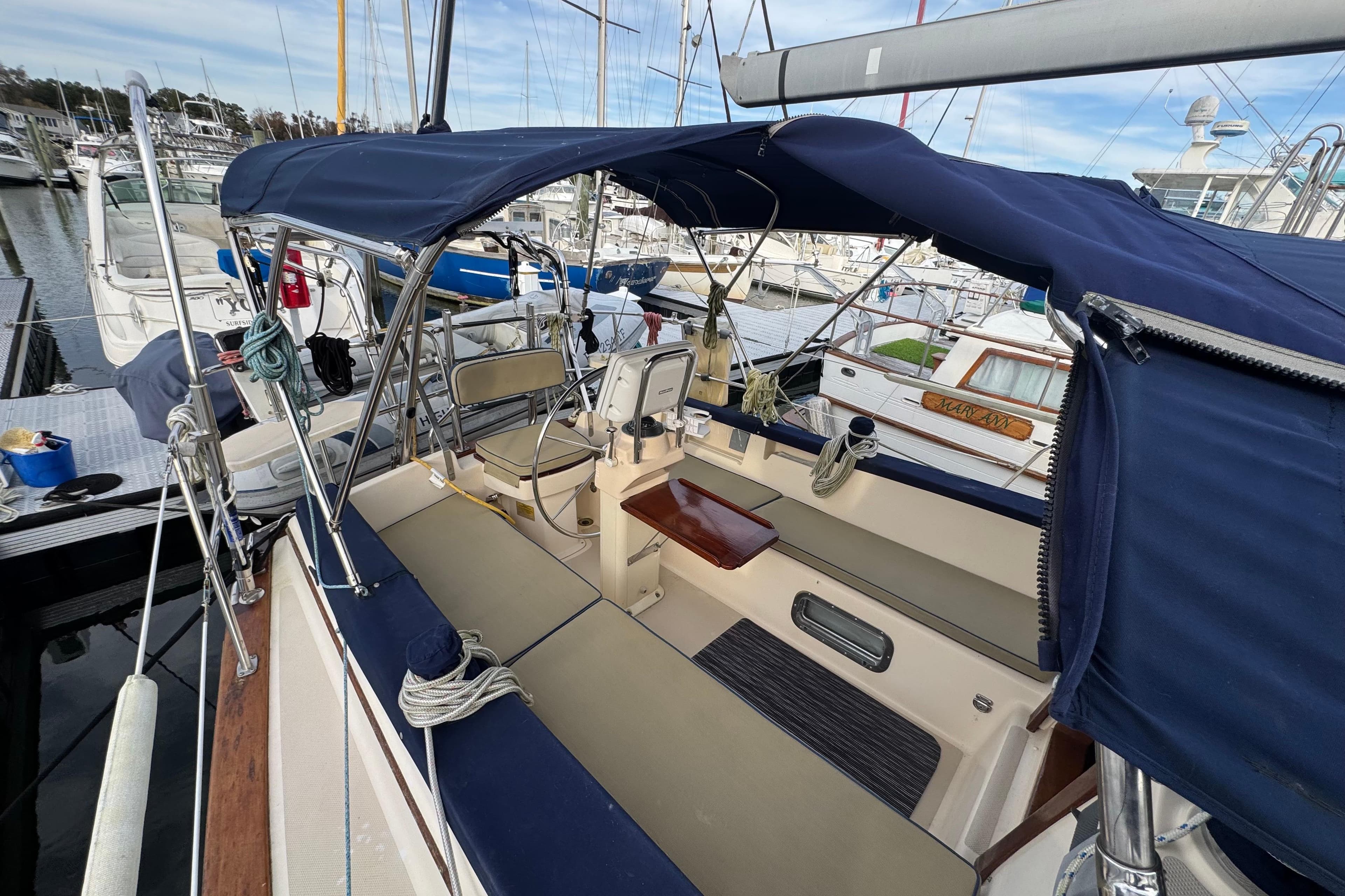 1999 Island Packet 350 sailboat cockpit with blue canopy, docked at marina.