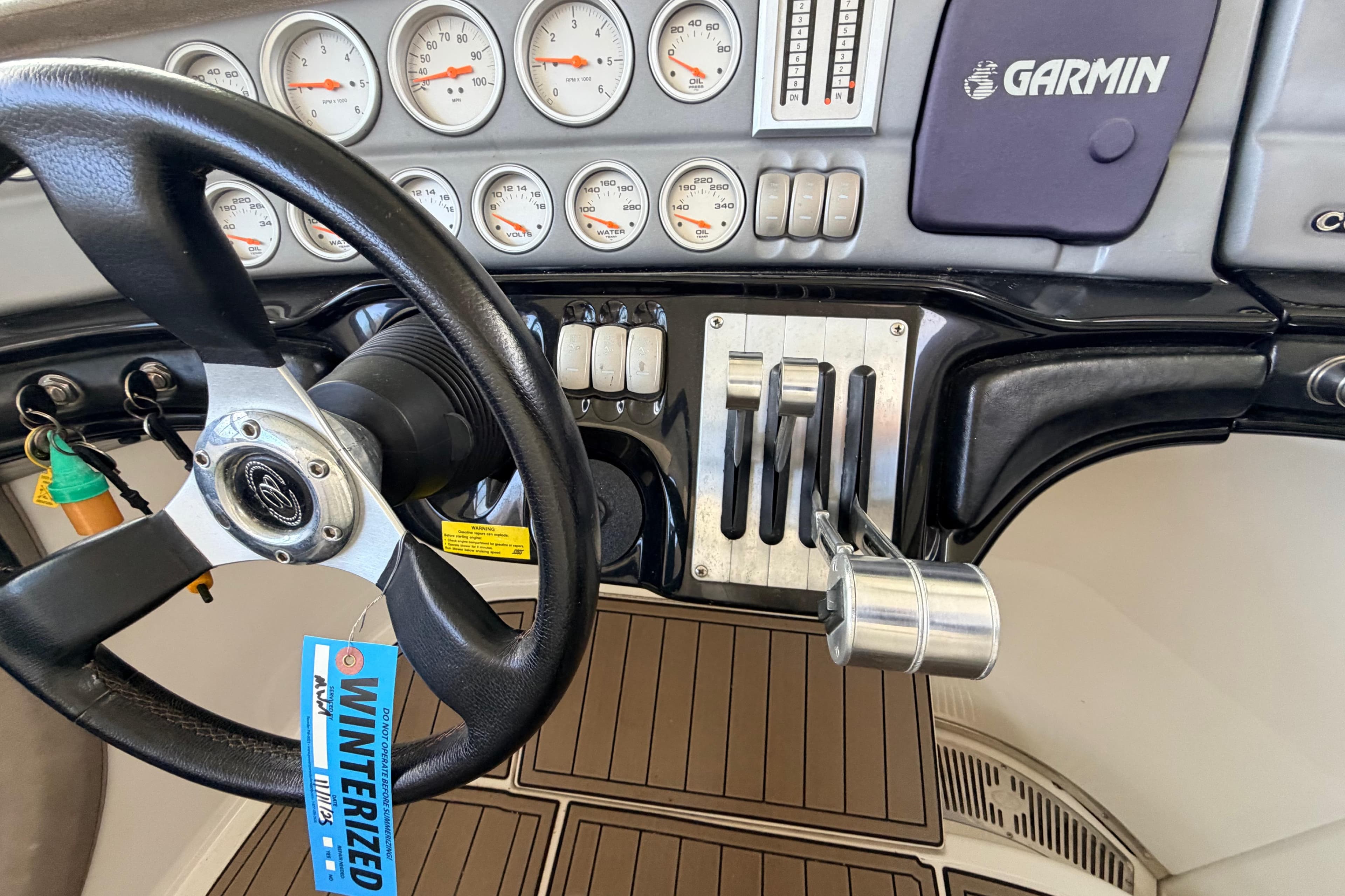 Steering wheel and controls of a 2004 Cobalt 343 boat with Garmin navigation.