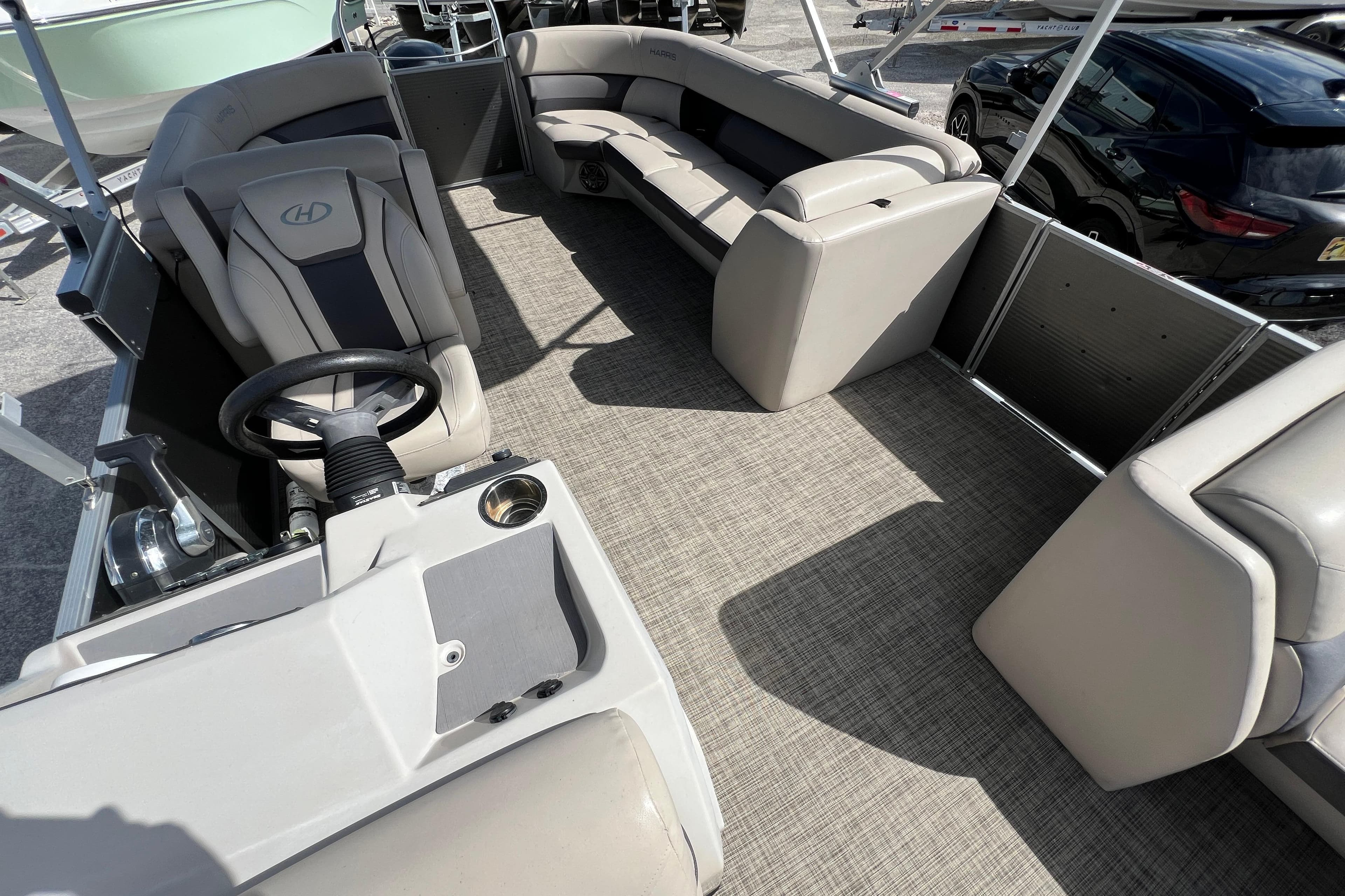 2023 Harris Cruiser 230 pontoon boat interior with plush seating and steering console.