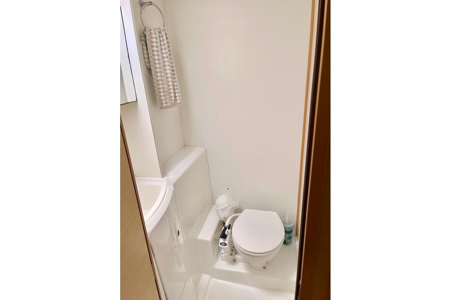 Compact bathroom in 2012 Lagoon 400 yacht with toilet and towel rack.