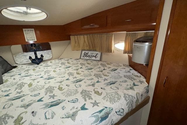 Cozy bedroom in 2006 Carver 36 Motor Yacht with nautical-themed bedding and decor.