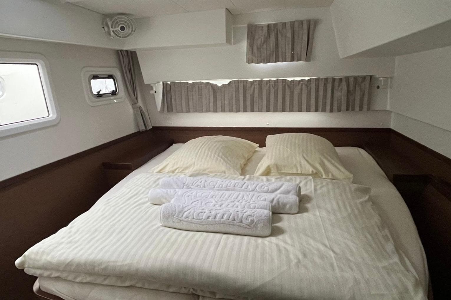 Cozy cabin interior of 2020 Lagoon 42 yacht with neatly arranged bed and towels.