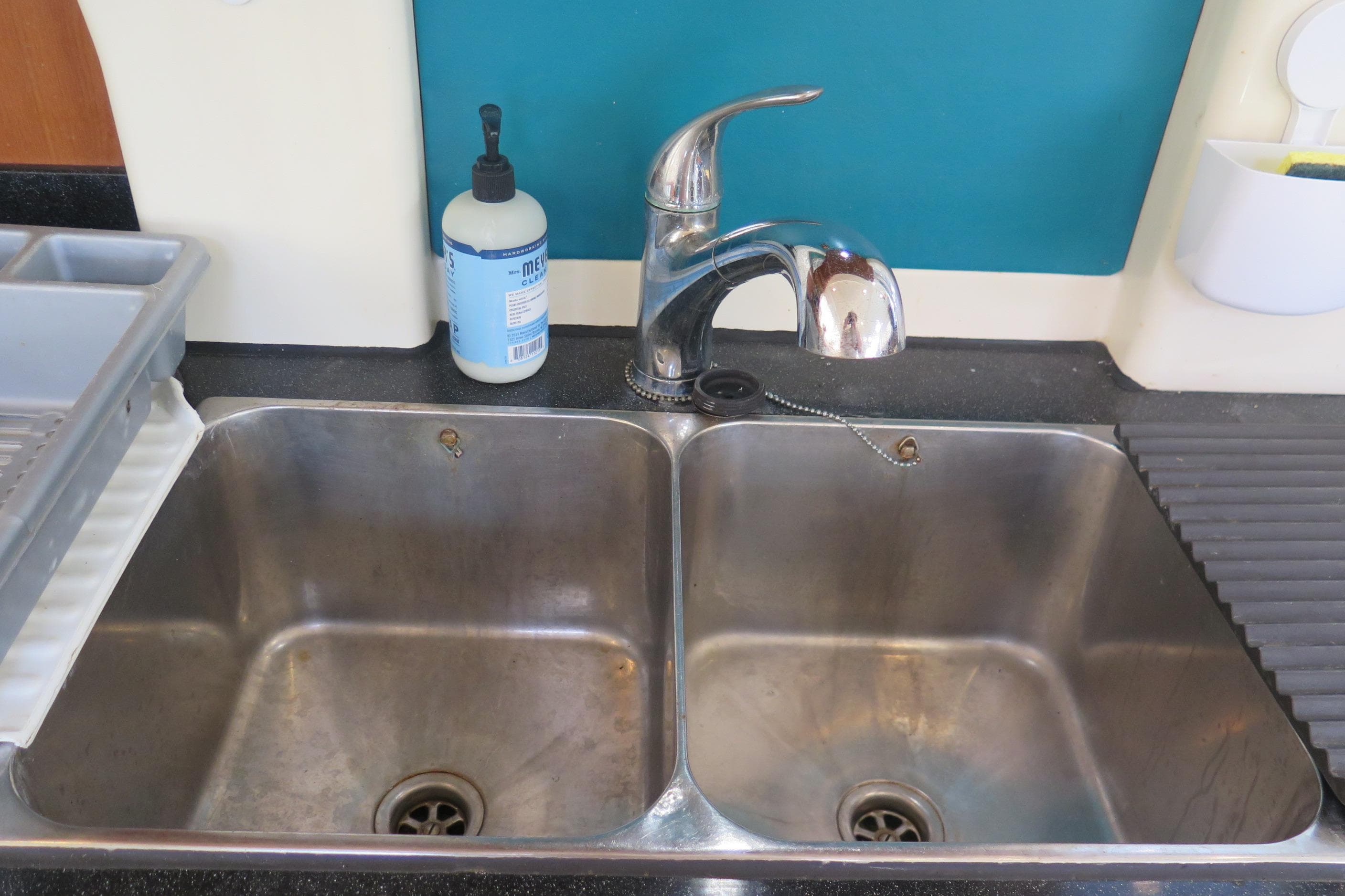 Stainless steel double sink with faucet, soap dispenser, and drying rack on Leopard 46 yacht.