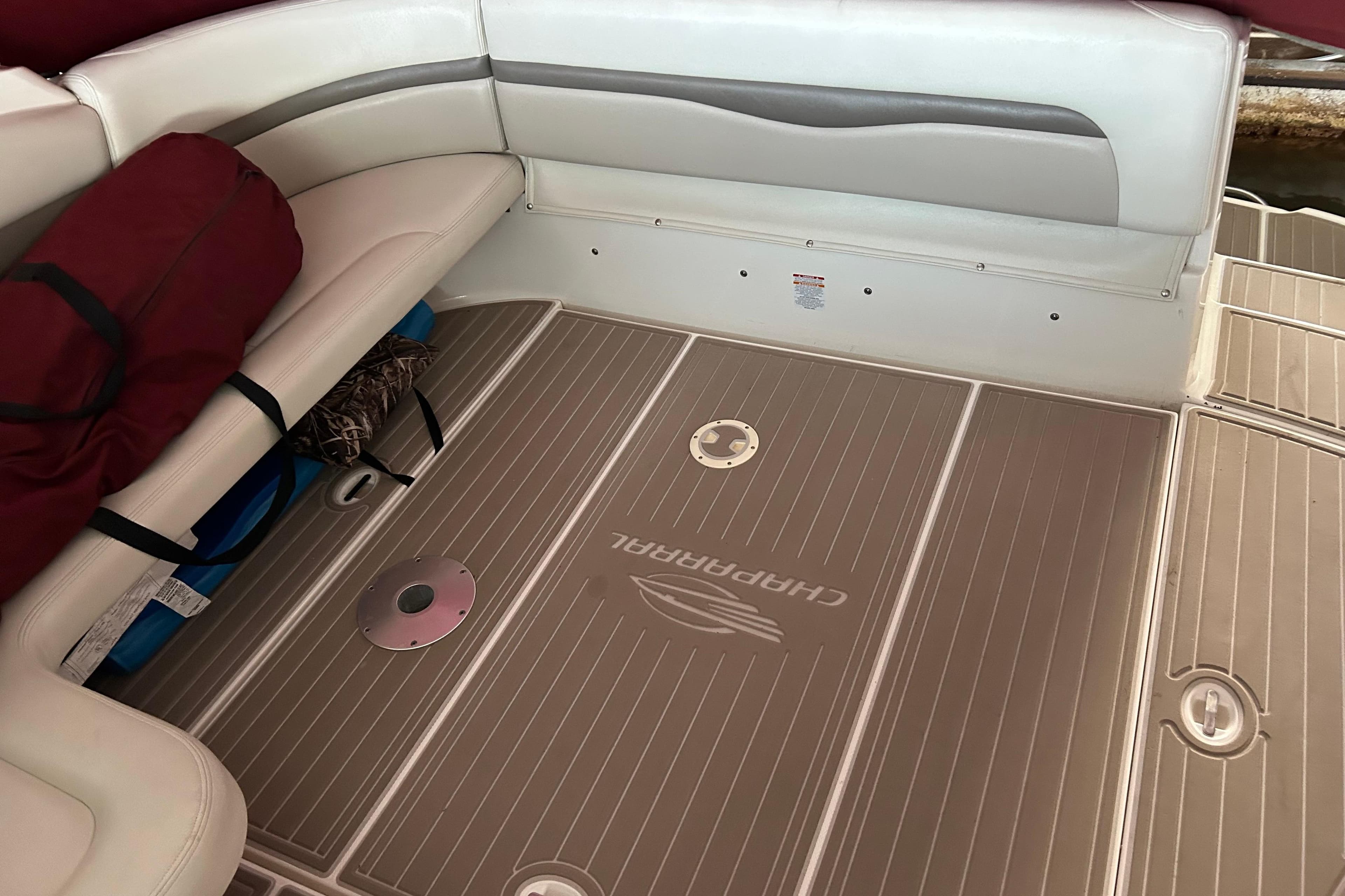 2010 Chaparral Signature 370 boat interior with cushioned seating and branded flooring.