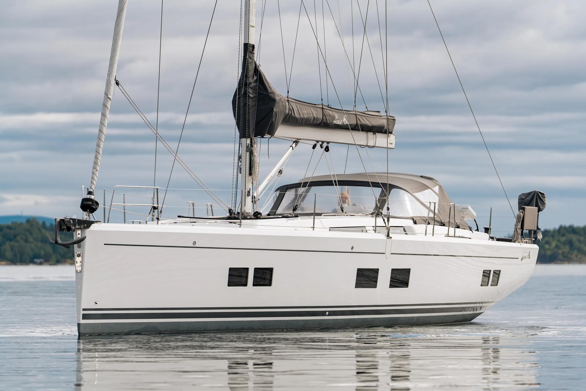 2019 Hanse 548 sailboat on calm water under cloudy sky.