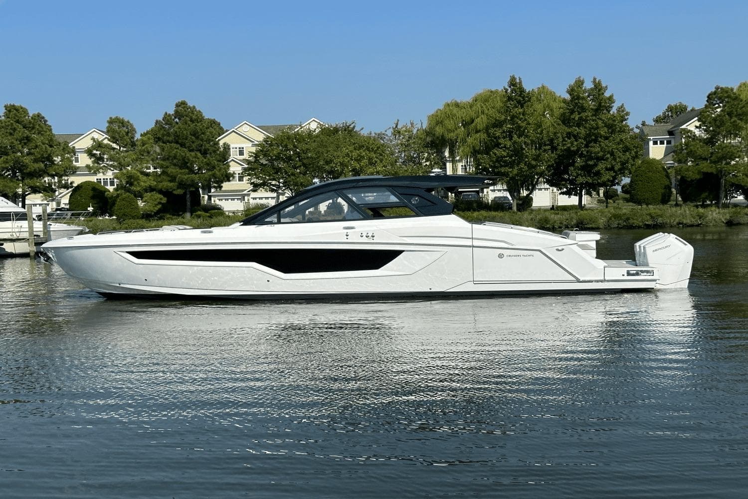 2024 Cruisers Yachts 50 GLS luxury boat on a serene waterway.