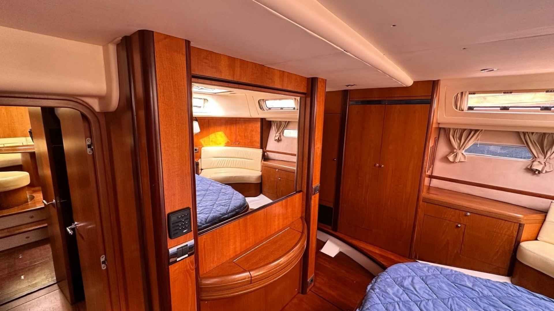 Luxurious Moody 64 yacht interior, featuring wood paneling, cozy seating, and elegant design, 2004 model.