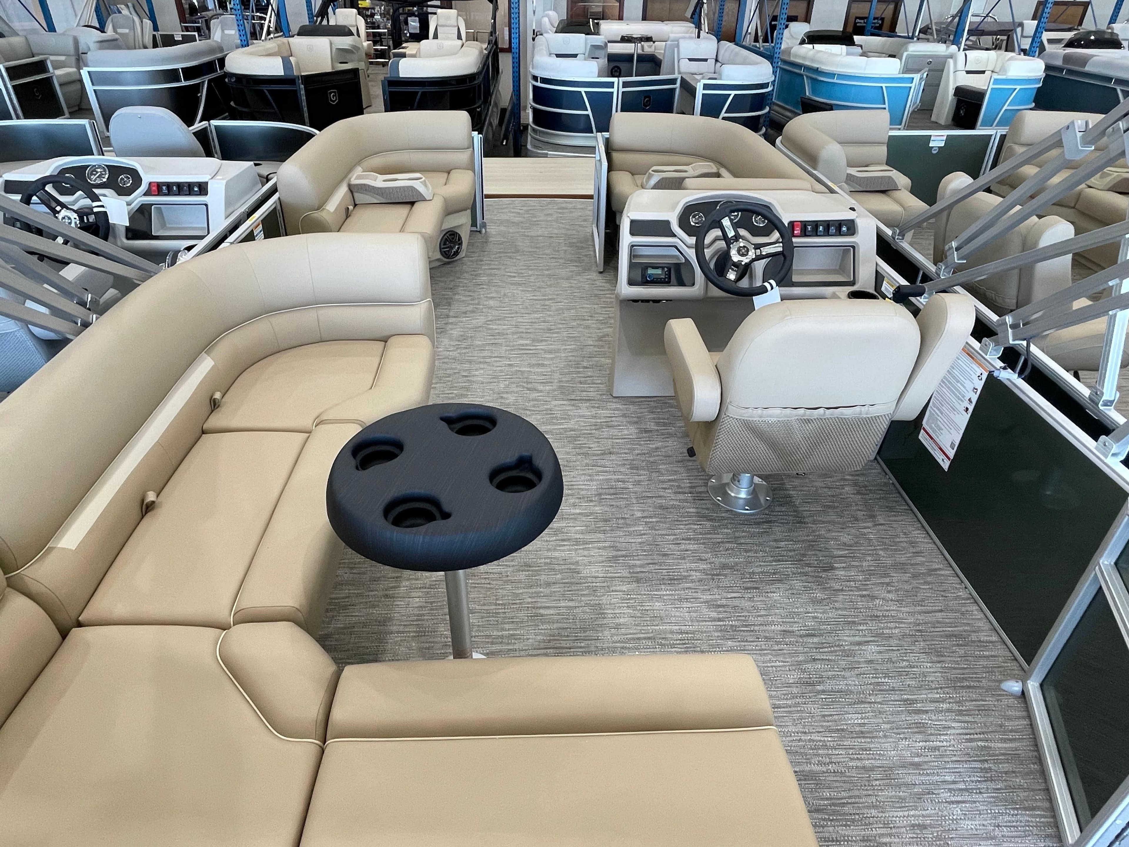 Interior of 2026 Godfrey Xperience 2086 CX pontoon boat with beige seating and steering console.