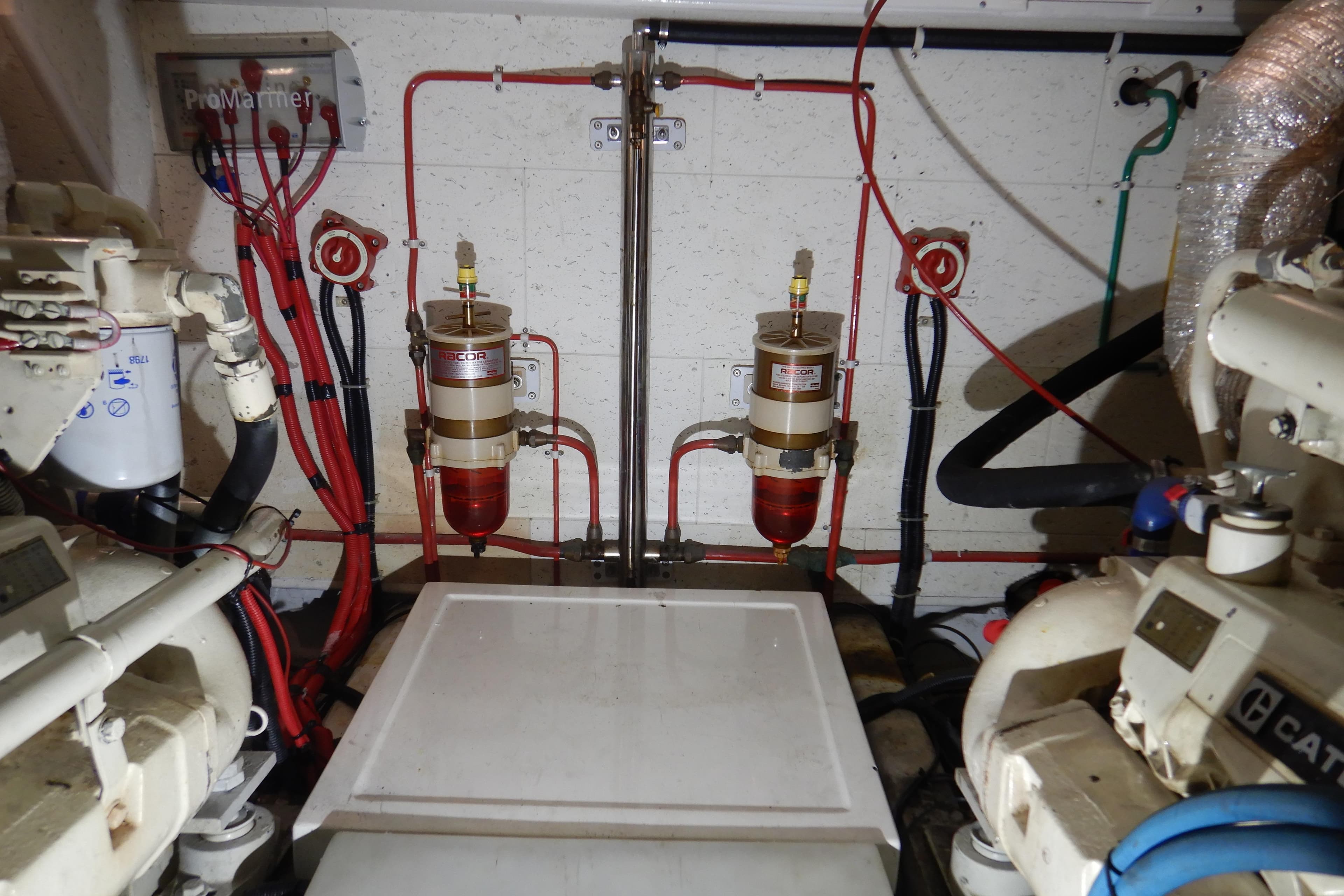 Engine room of 1988 Camargue 48 Cockpit Motor Yacht with fuel filters and wiring.