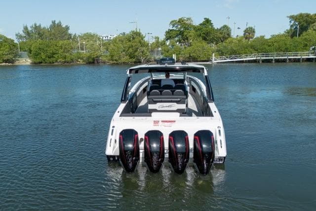 2025 Cigarette 42' Auroris boat with multiple engines on a calm waterway.