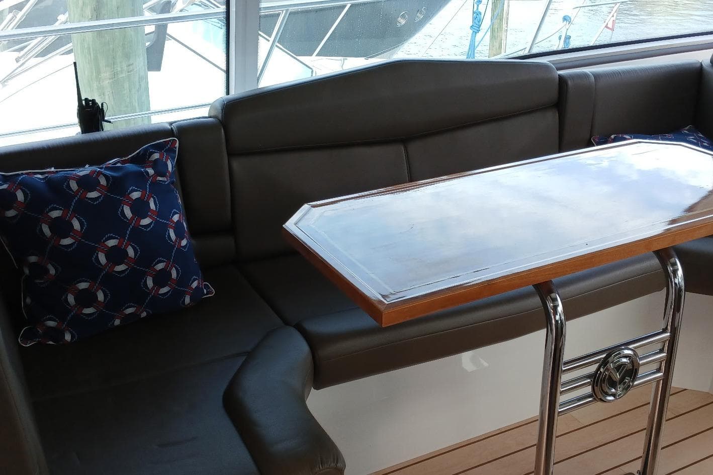 Interior of 2014 Cruisers Yachts 41 Cantius with cushioned seating and nautical-themed pillows.