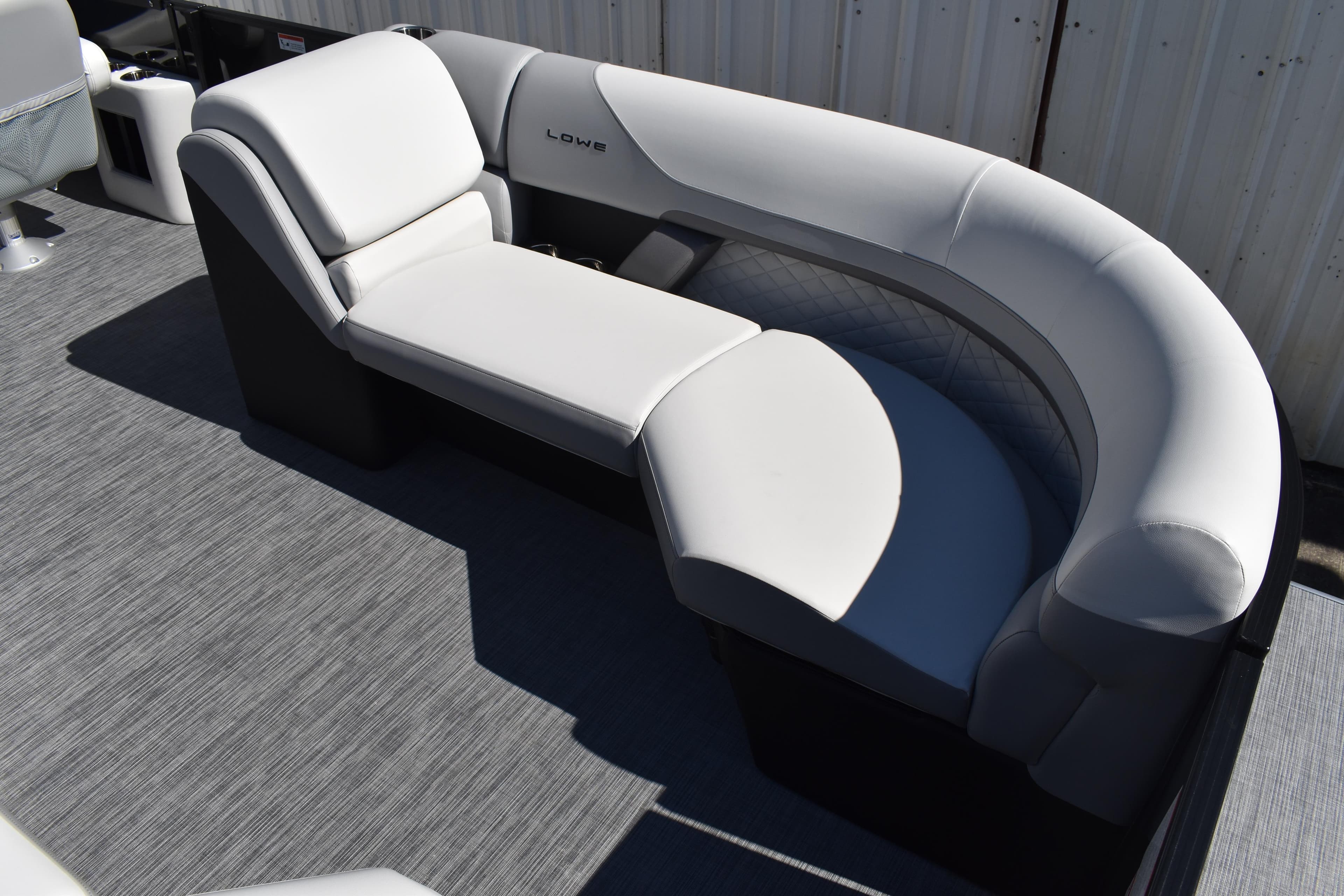 Luxurious seating on 2026 Lowe SS 230 WT pontoon boat, featuring sleek white upholstery.