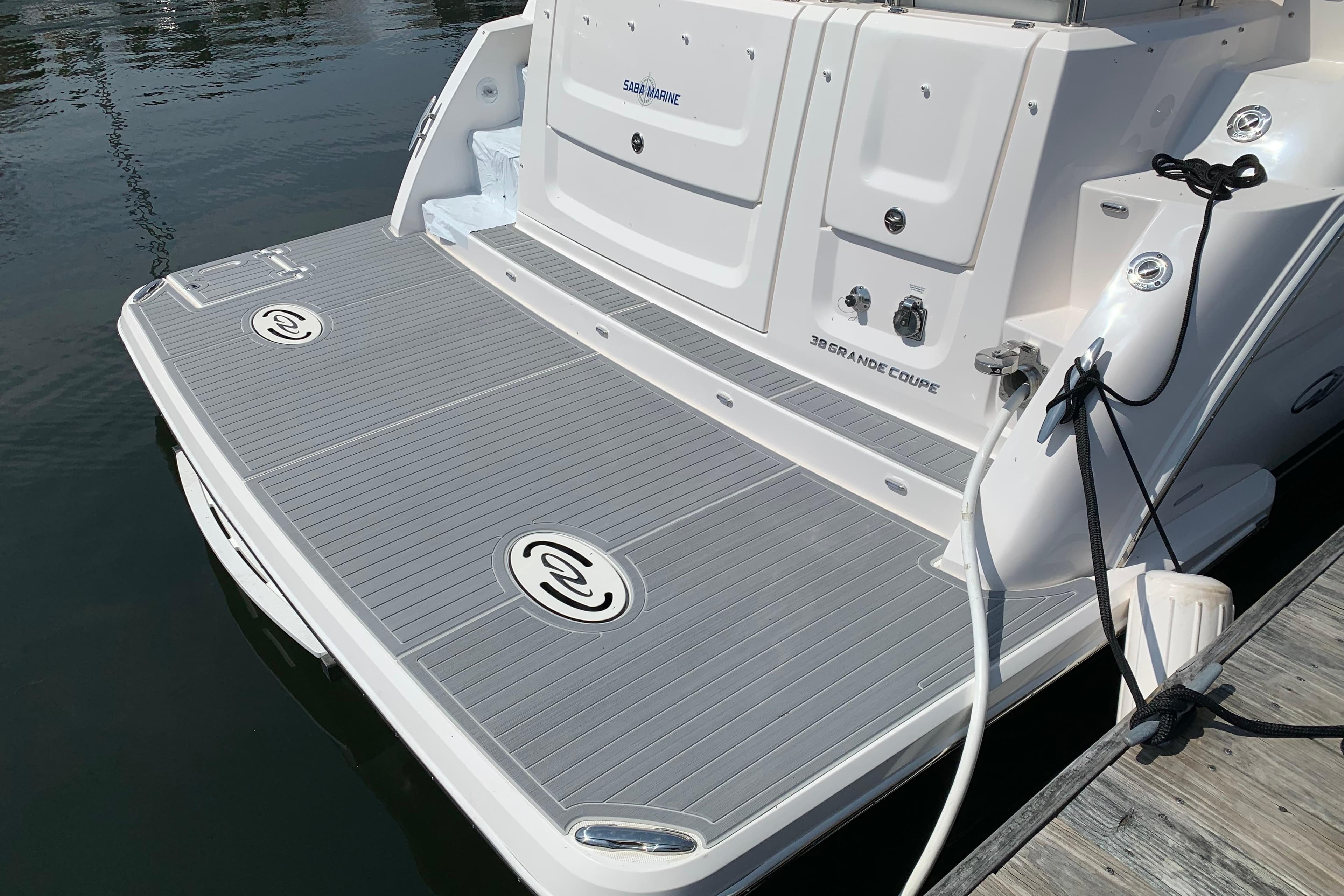 2025 Regal 38 Grande Coupe boat stern with swim platform and docked at marina.