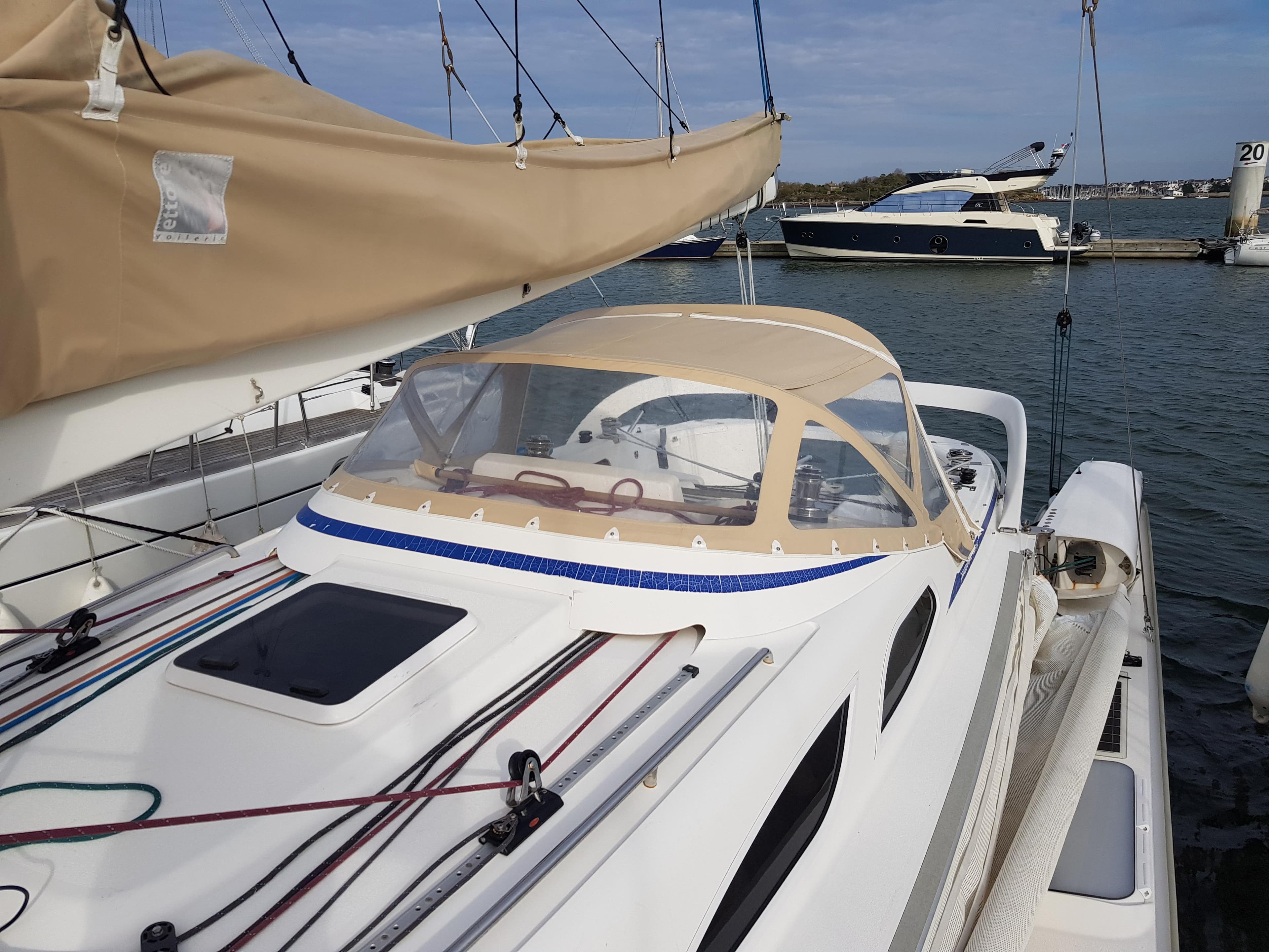 2009 Dragonfly 35 Touring sailboat docked, featuring beige canopy and sleek design.