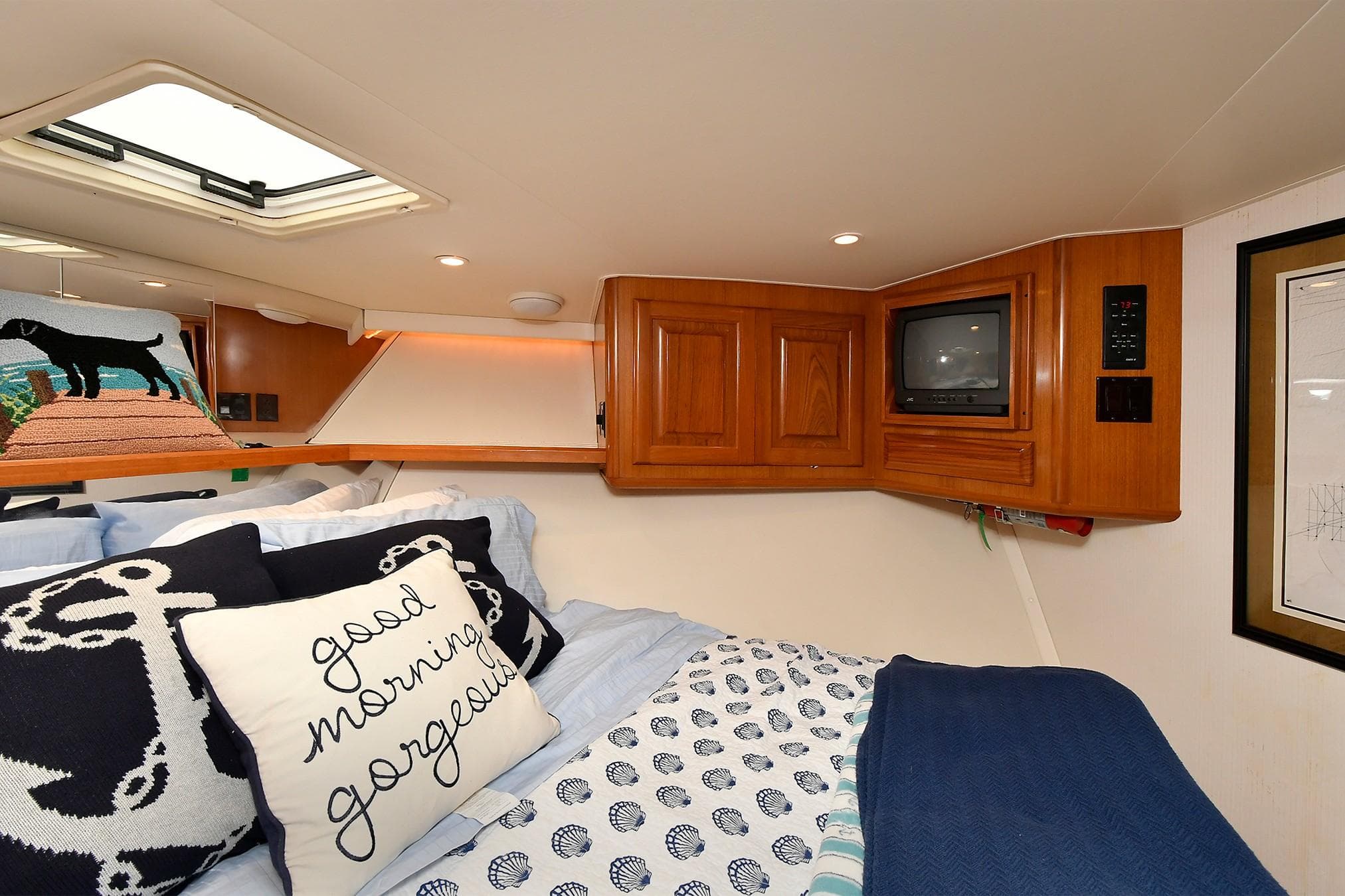 Cozy cabin interior of 1997 Viking 47 Convertible with TV and decorative pillows.