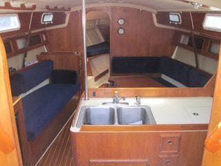 Interior of 1986 Pearson 36-2 sailboat with wood finish and blue seating.
