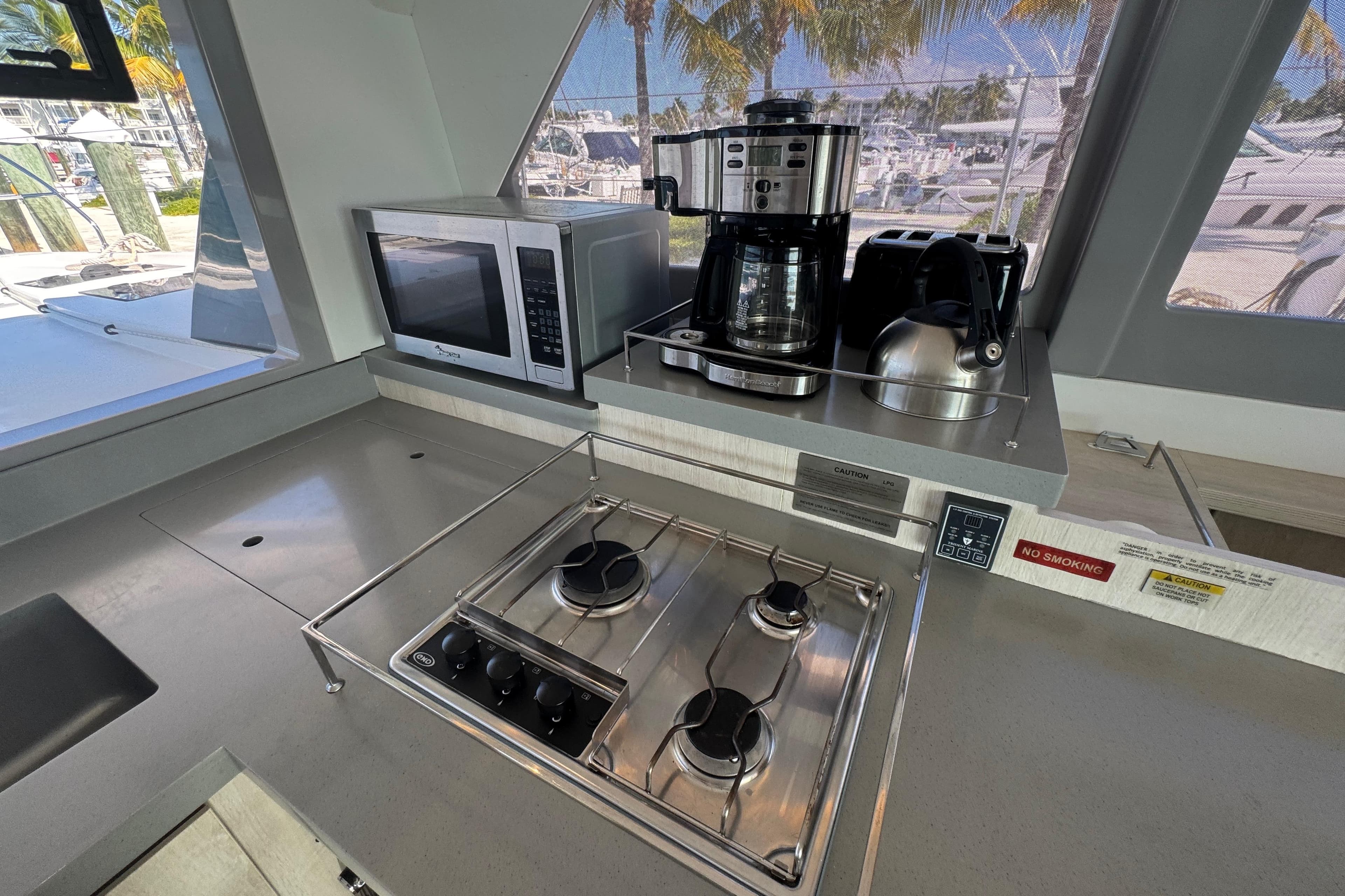Modern kitchen in 2021 Leopard 45 yacht with stove, microwave, and coffee maker.