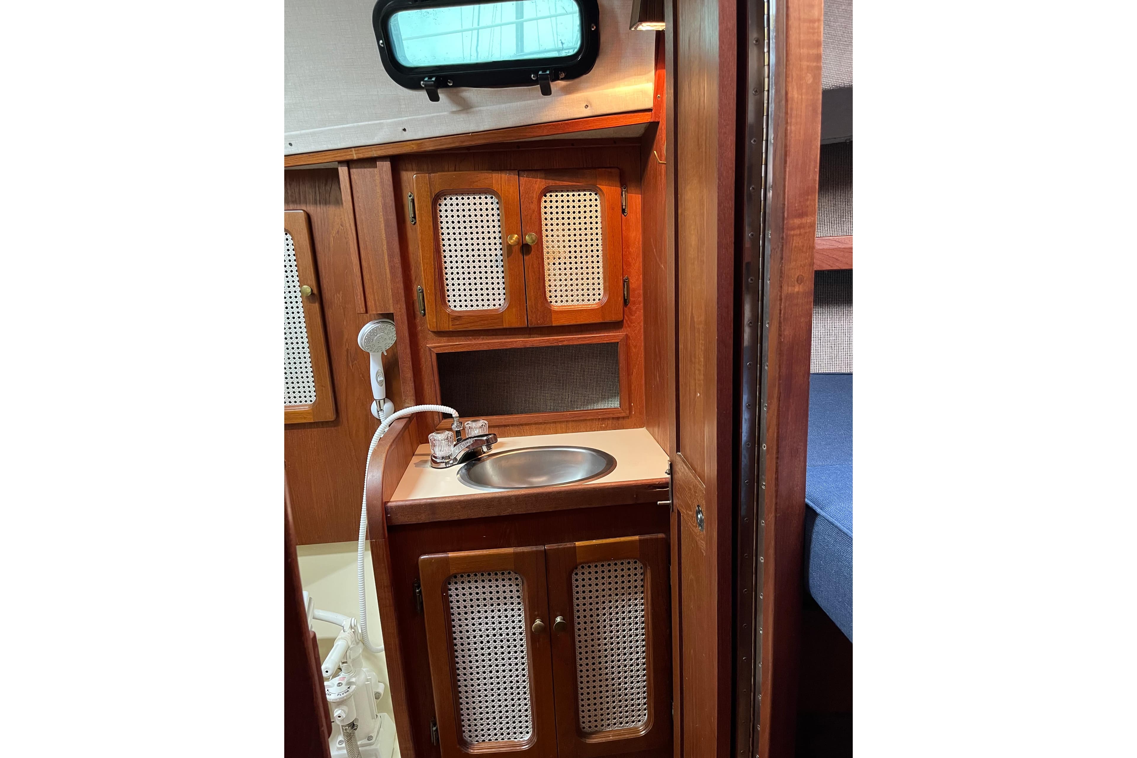 1985 S2 11.0 meter A yacht interior with wooden cabinetry and compact sink.