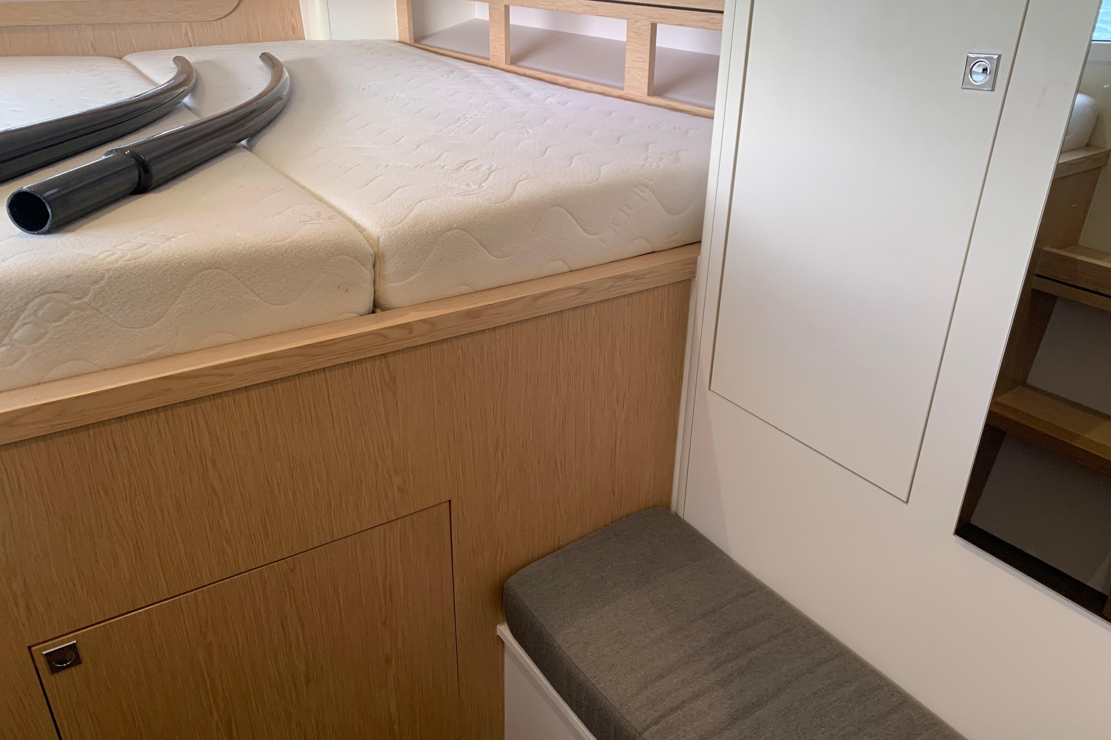 Interior of 2021 Outremer 51 yacht, featuring a cozy cabin with a mattress and storage.