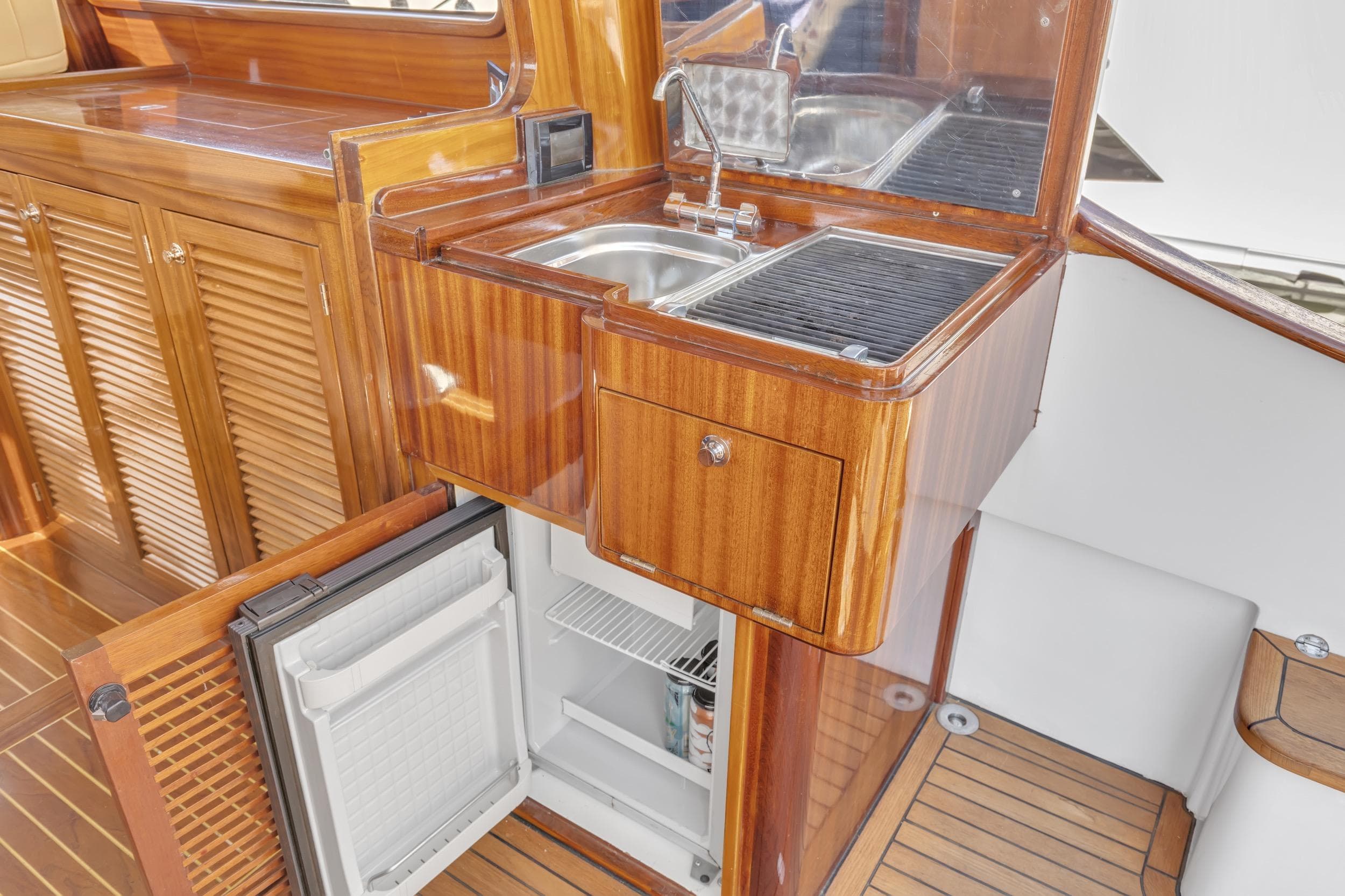 Luxurious 2007 Gorbon Custom Downeast 40 yacht interior with wooden cabinetry and compact kitchen amenities.