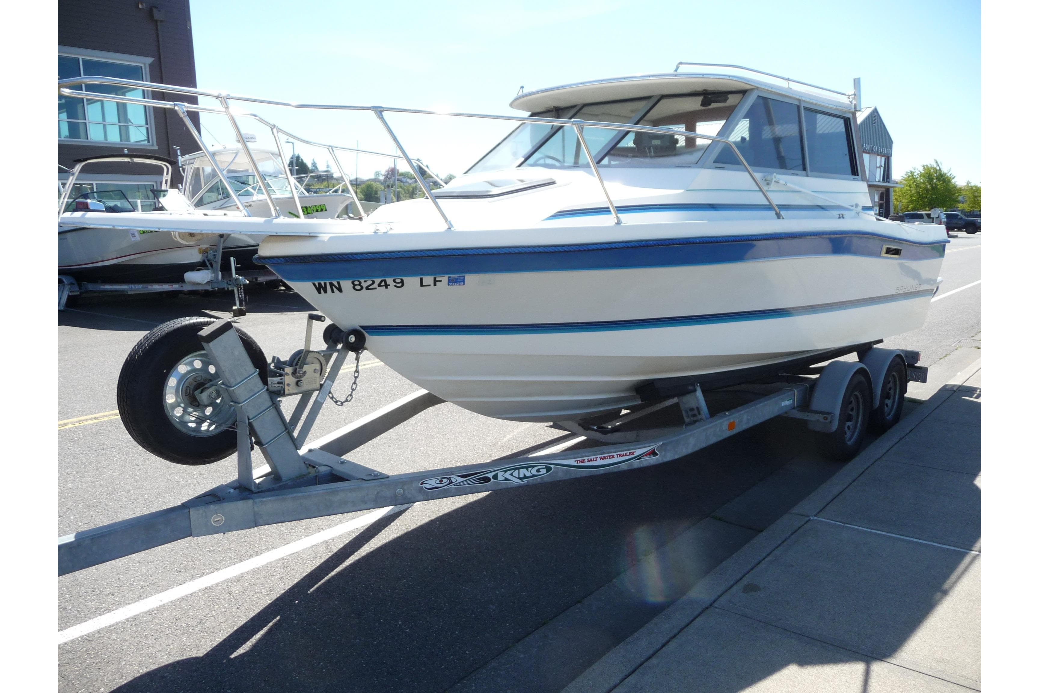 1988 Bayliner 2102 Trophy boat on trailer, parked on street, sunny day.
