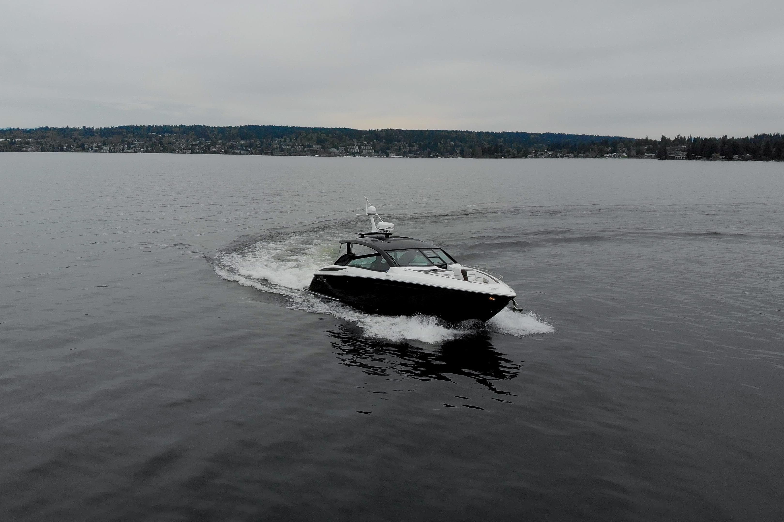 2019 Cobalt A36 boat cruising on a calm lake under overcast skies.