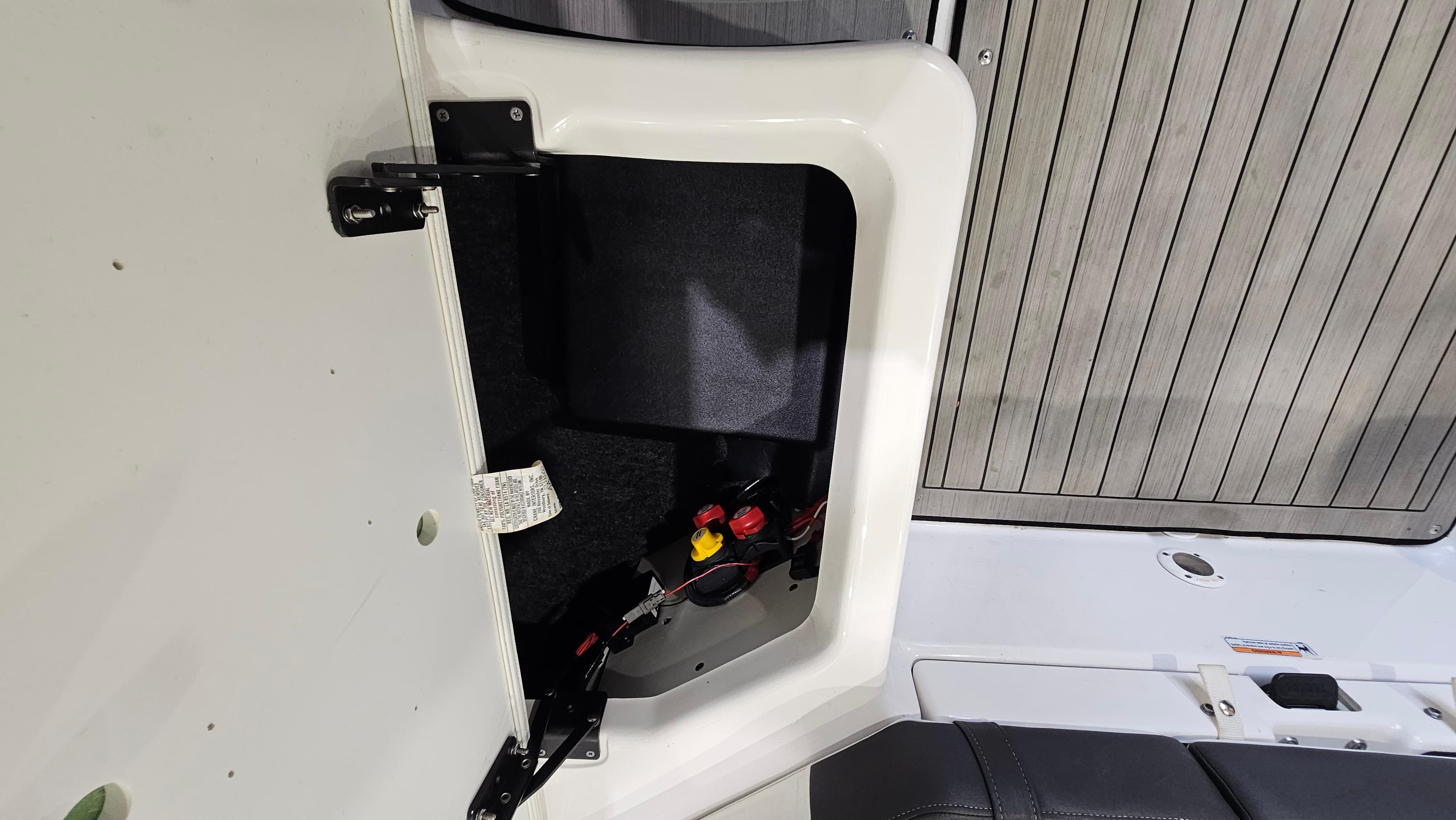 2021 Yamaha Boats 212SD storage compartment with open hatch, showcasing interior details and wiring.